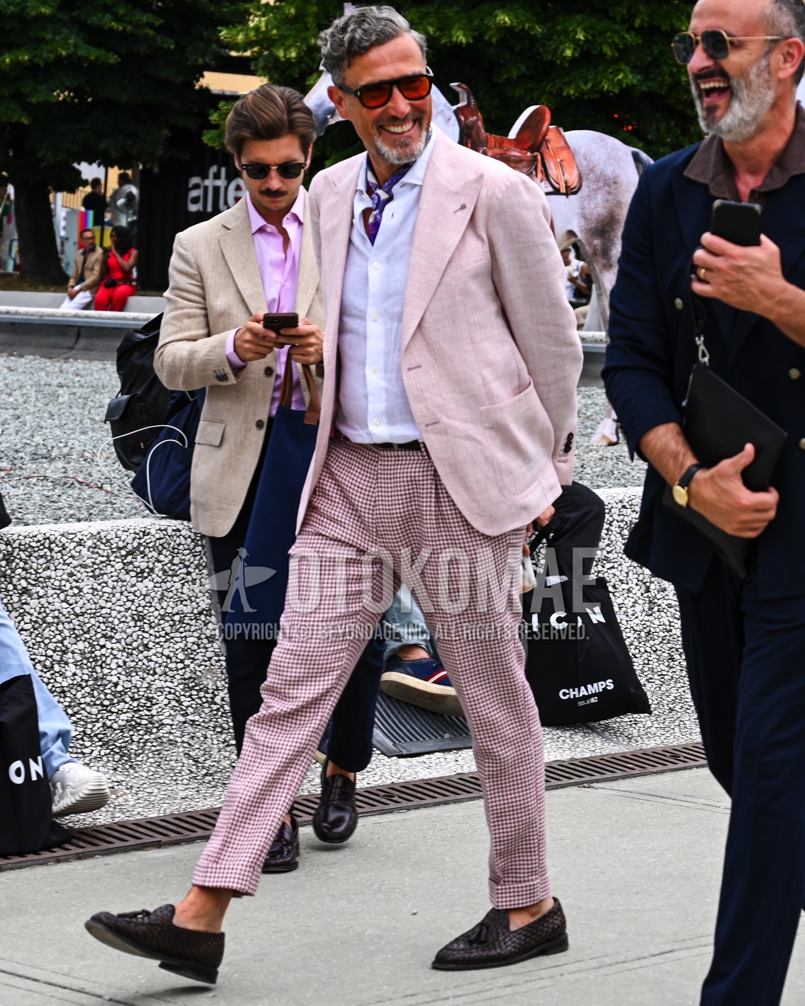 Men's spring summer autumn outfit with red plain sunglasses, purple plain bandana/neckerchief, pink plain tailored jacket, white plain shirt, brown plain leather belt, pink check pleated pants, brown tassel loafers leather shoes.