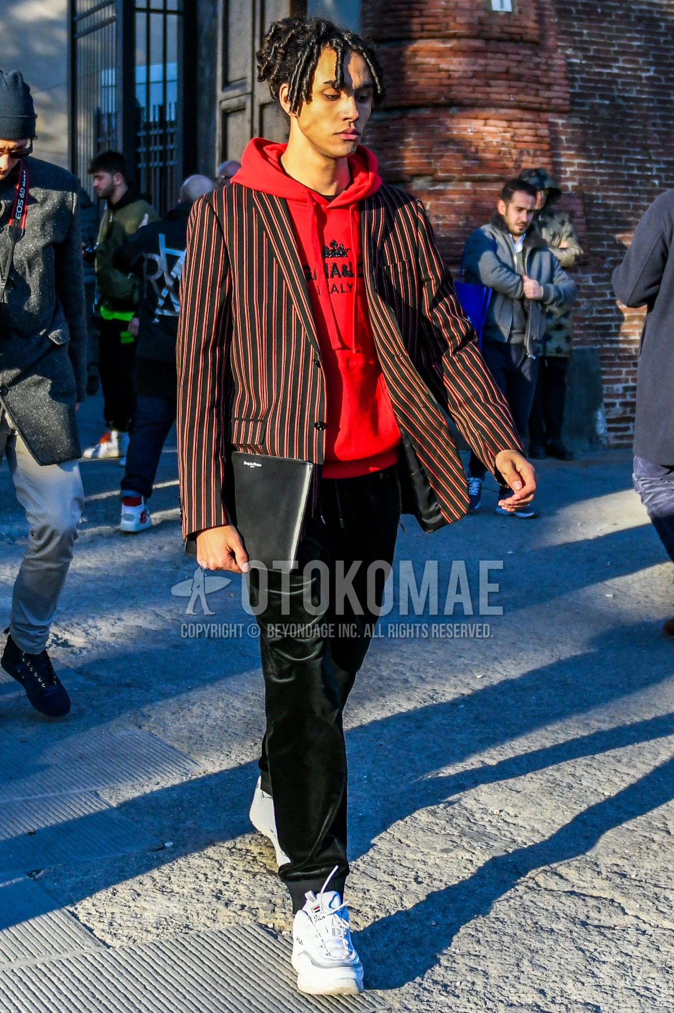 Men's winter outfit with red stripes tailored jacket, red plain hoodie, black plain winter pants (corduroy,velour), white low-cut sneakers.
