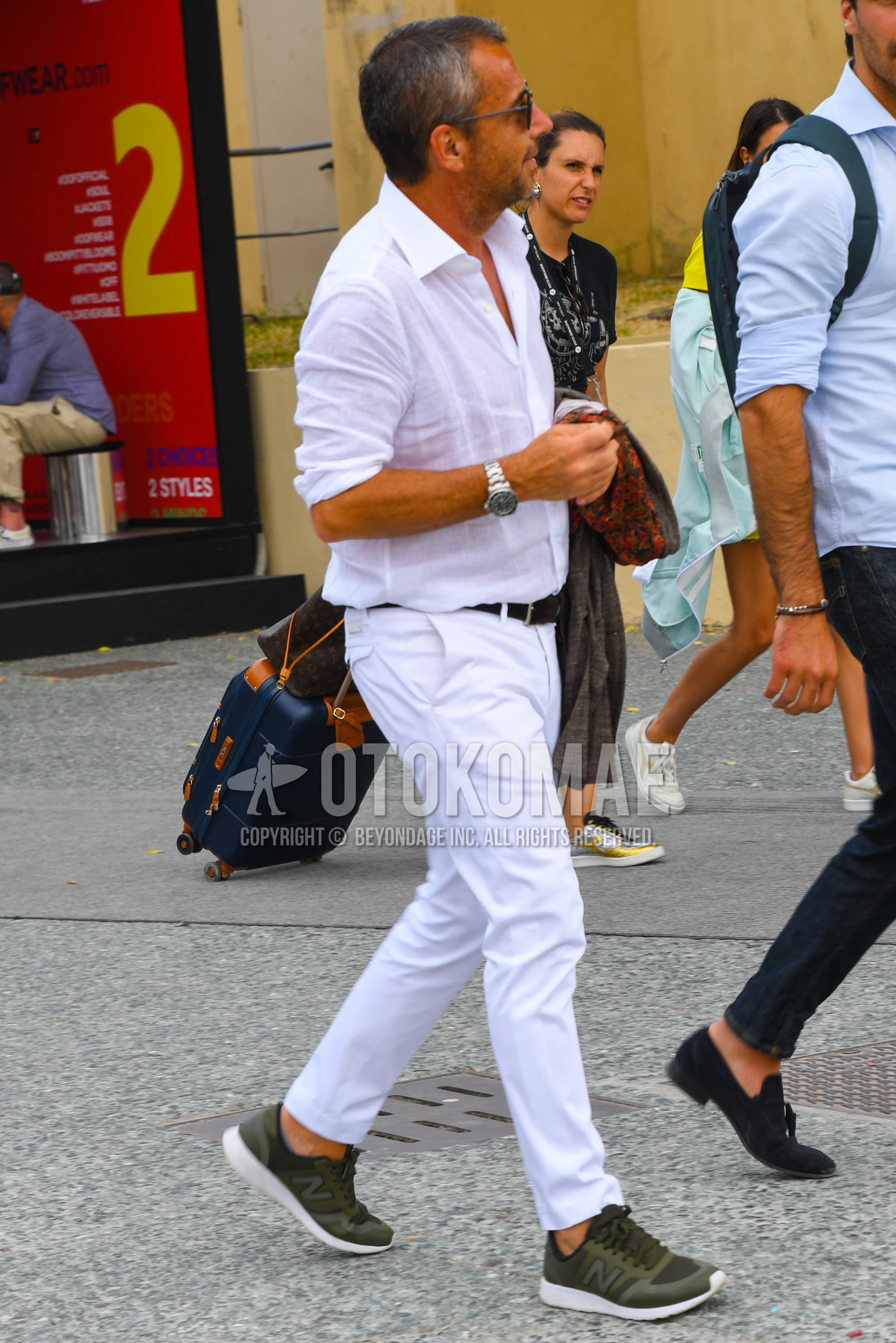 Men's spring summer outfit with white plain shirt, black plain leather belt, white plain cotton pants, olive green low-cut sneakers.