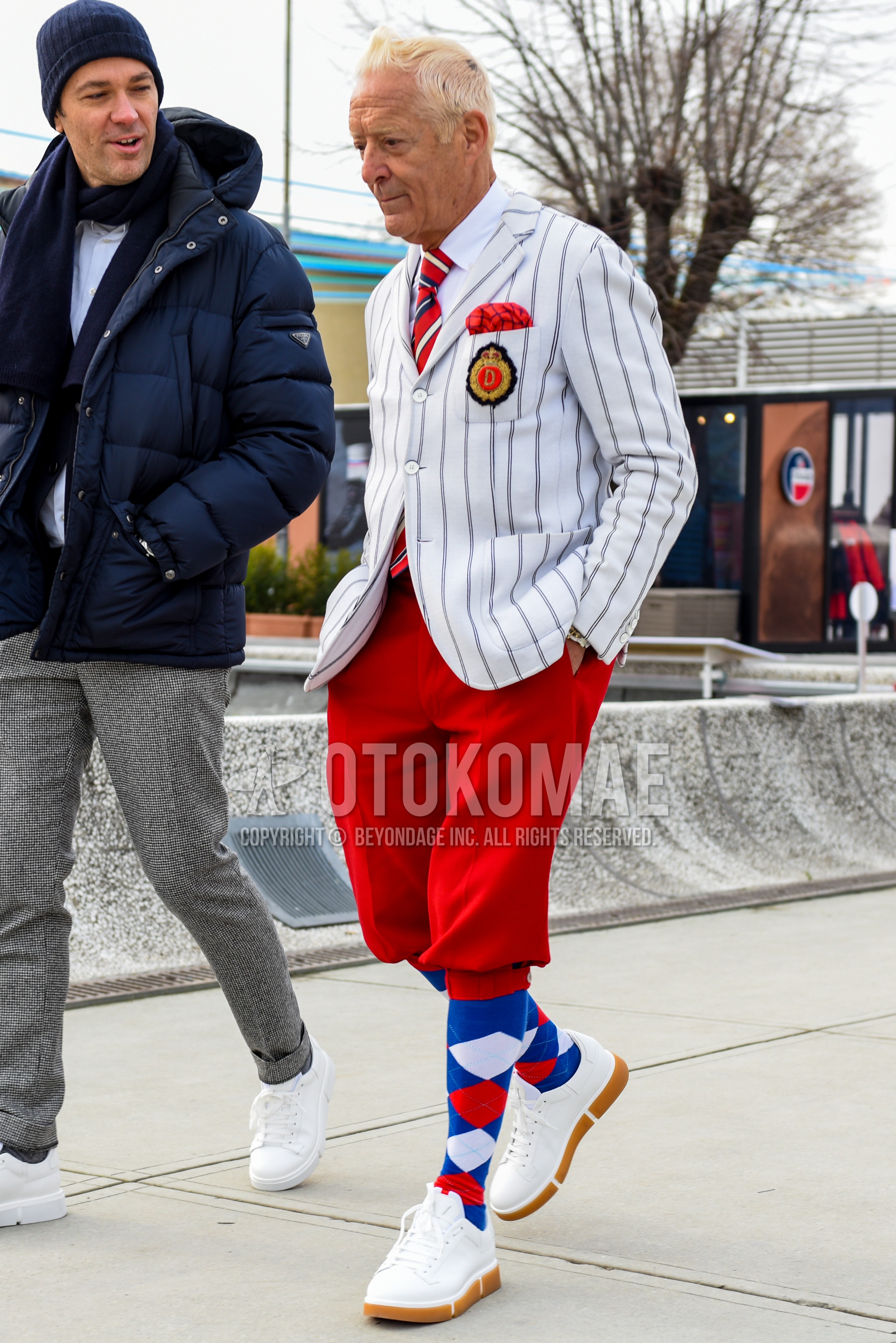 Men's autumn winter outfit with white stripes tailored jacket, white plain shirt, red plain short pants, blue socks socks, white low-cut sneakers, red regimental necktie.