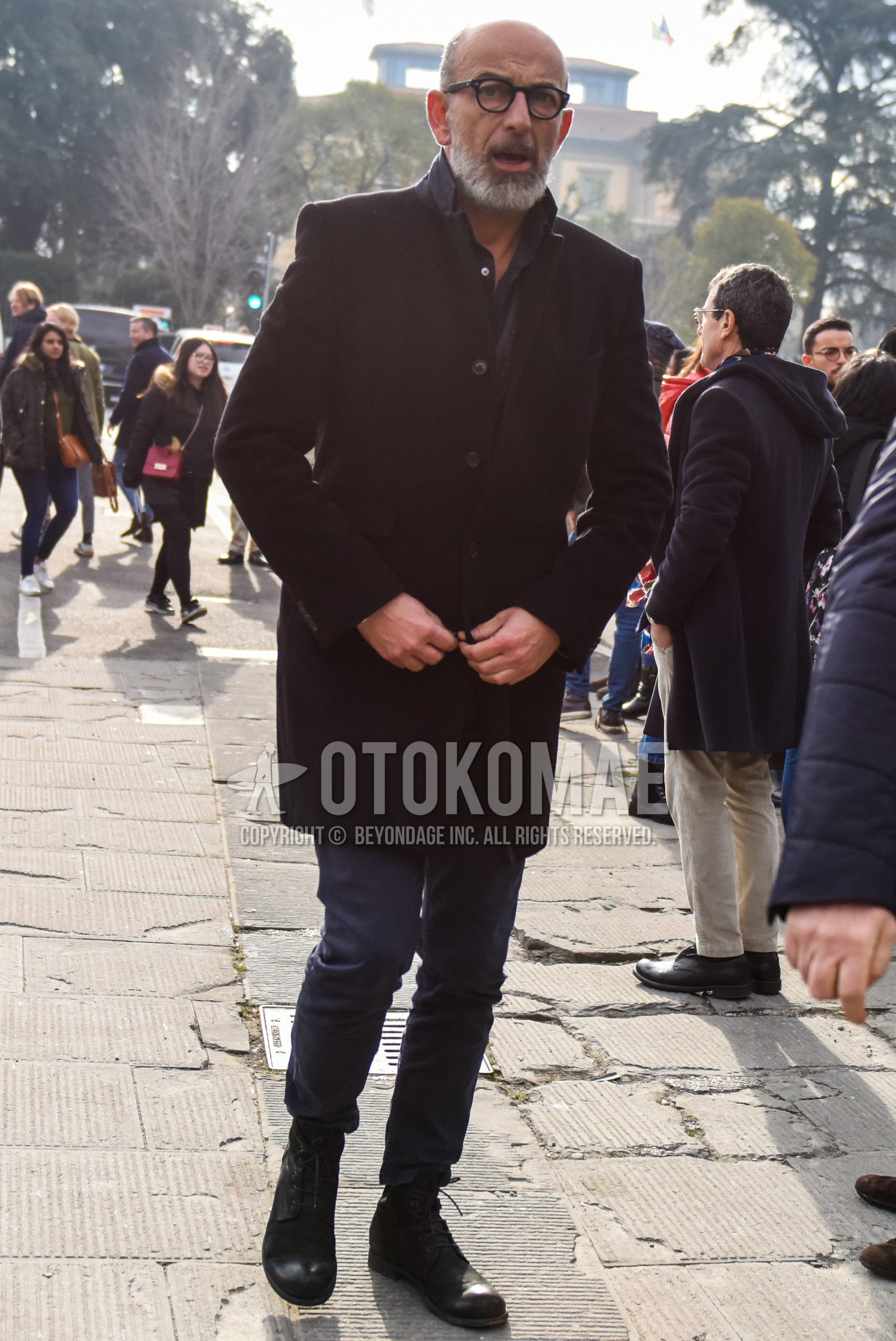 Men's winter outfit with plain glasses, black plain chester coat, dark gray plain denim/jeans, black  boots.