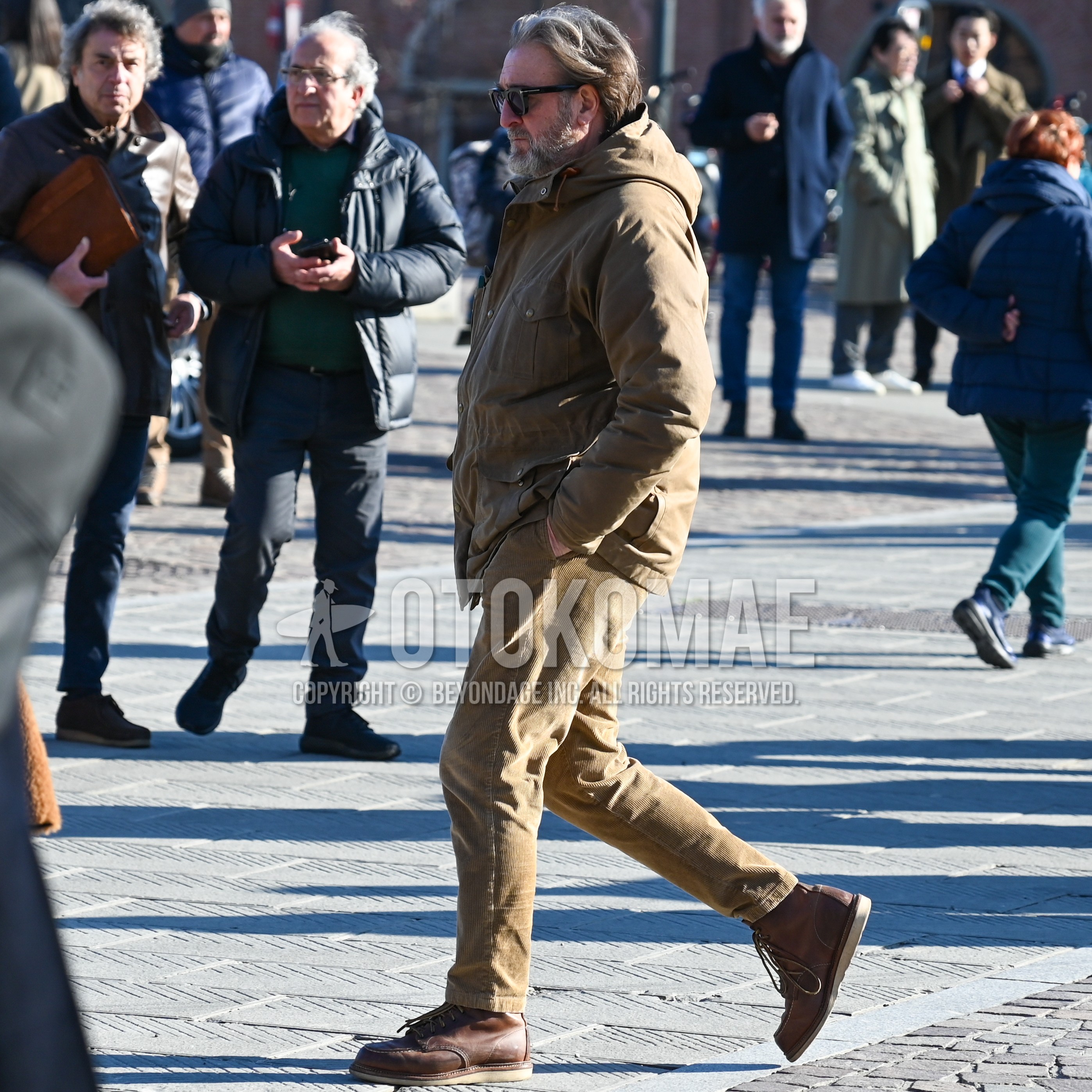 Men's autumn winter outfit with black eyewear sunglasses, brown outerwear hooded coat, brown plain winter pants (corduroy,velour), brown work boots.
