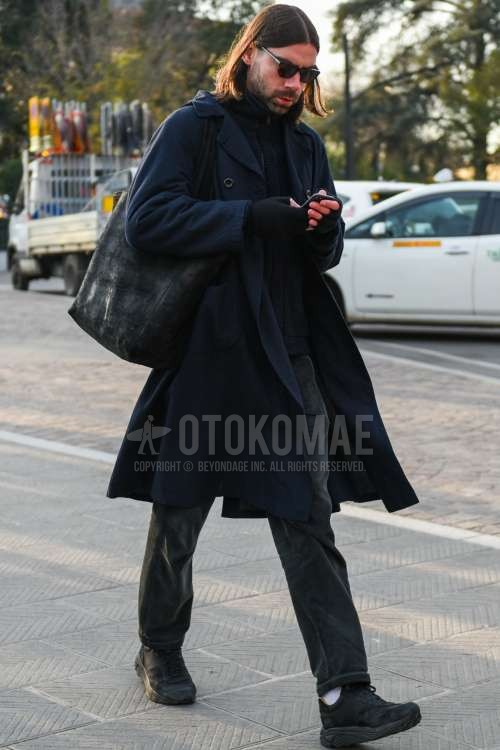 ウェリントン のブラウンべっ甲のサングラス、ネイビー無地のトレンチコート、黒無地のフリースジャケット、グレー無地のデニム/ジーンズ、白無地のソックス、黒ローカットのスニーカー、黒無地のトートバッグを合わせた秋冬のメンズコーデ・着こなし。