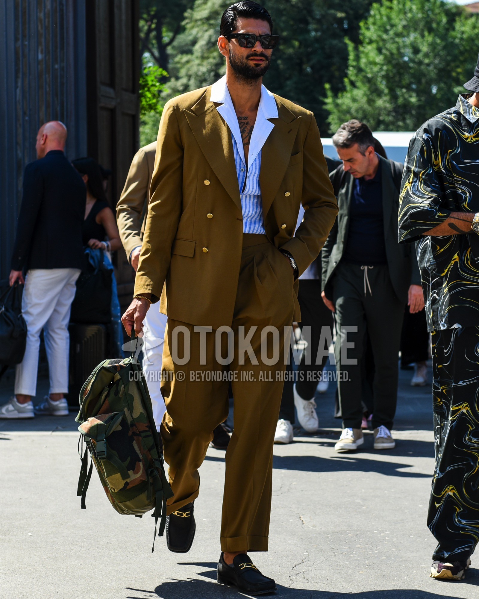 Men's spring summer outfit with black plain sunglasses, blue white stripes shirt, black bit loafers leather shoes, olive green camouflage backpack, olive green plain suit.