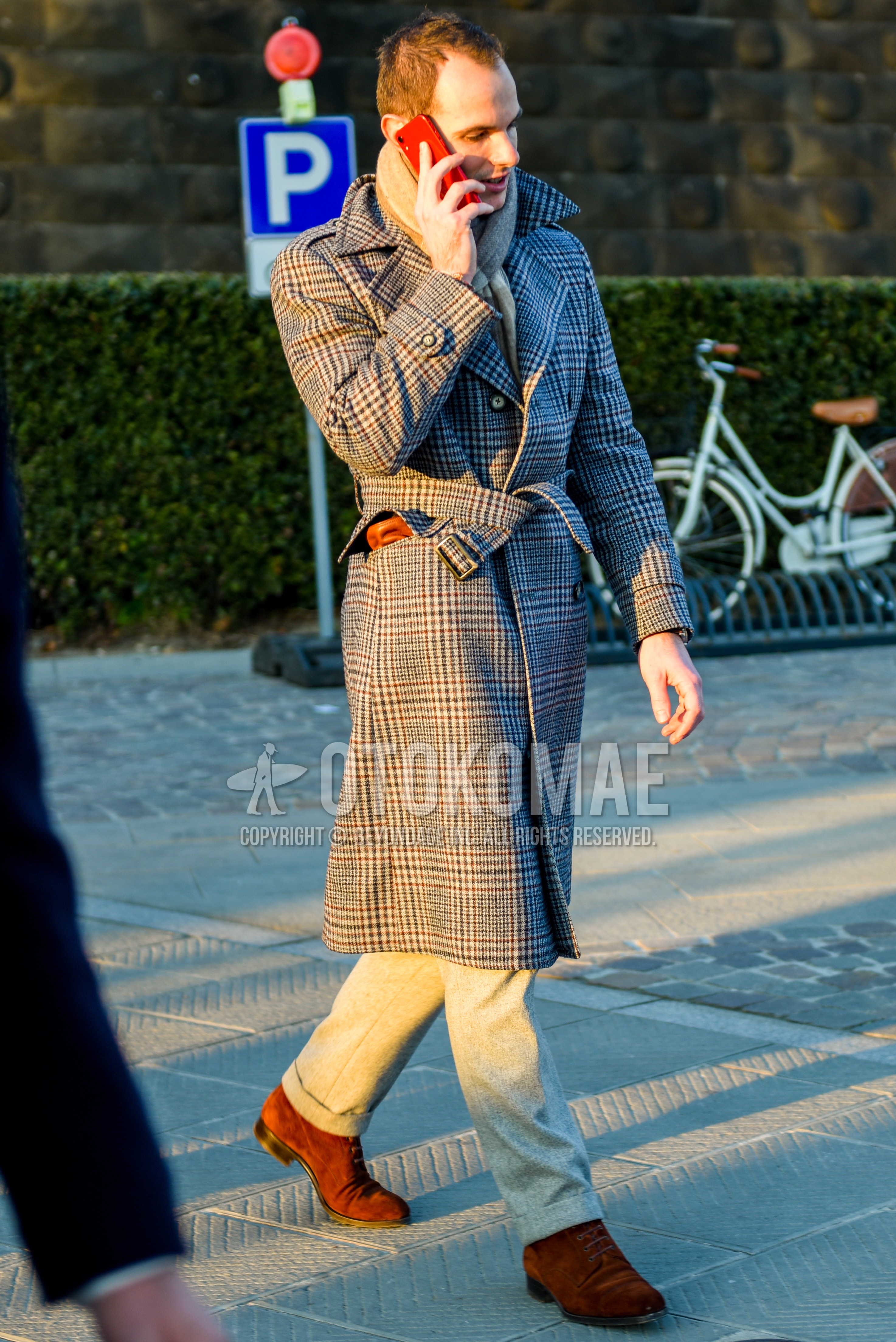 Men's autumn winter outfit with gray plain scarf, gray check trench coat, gray plain slacks, brown  boots.