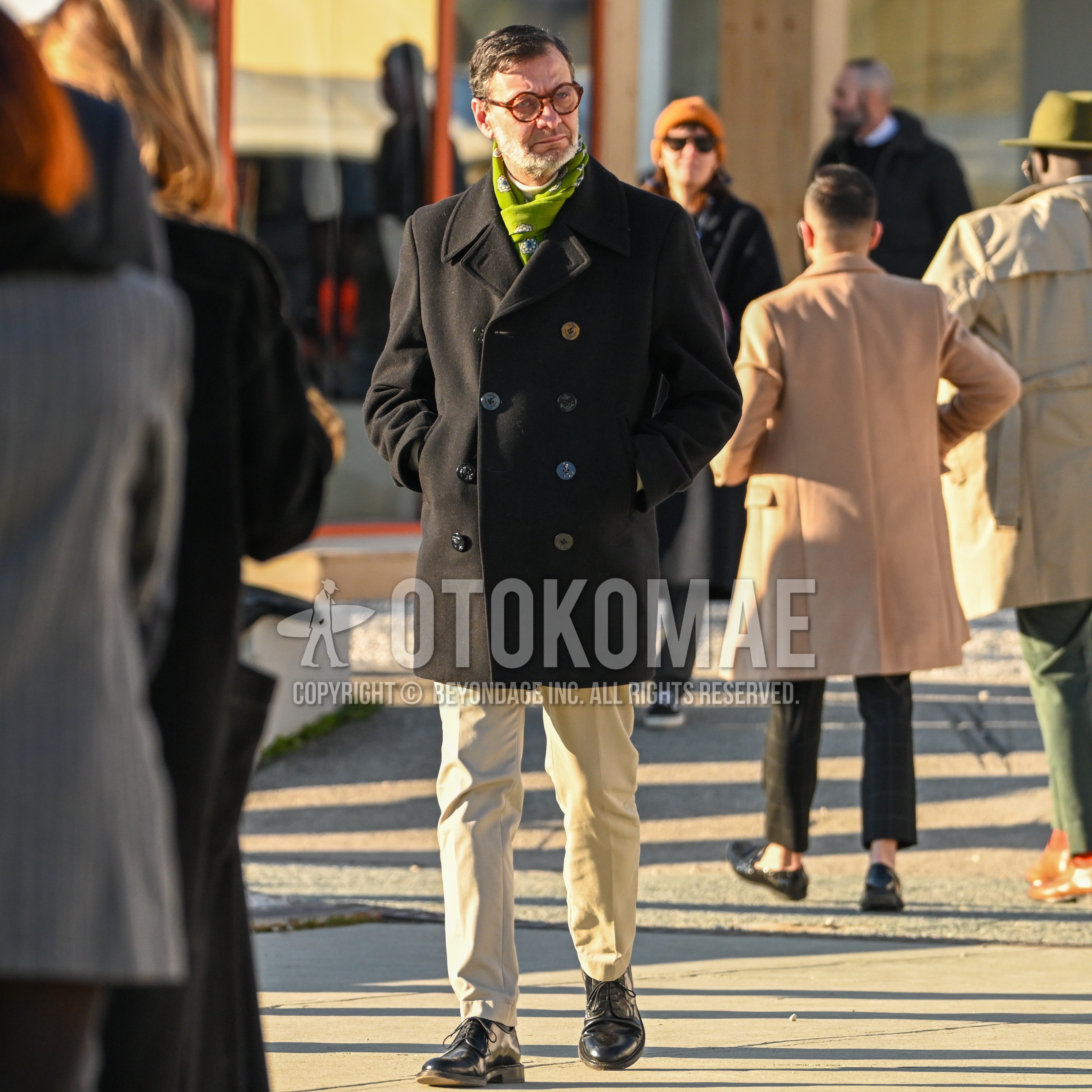 Men's autumn winter outfit with tortoiseshell glasses, green whole pattern scarf, black plain p coat, beige plain chinos, black straight-tip shoes leather shoes.