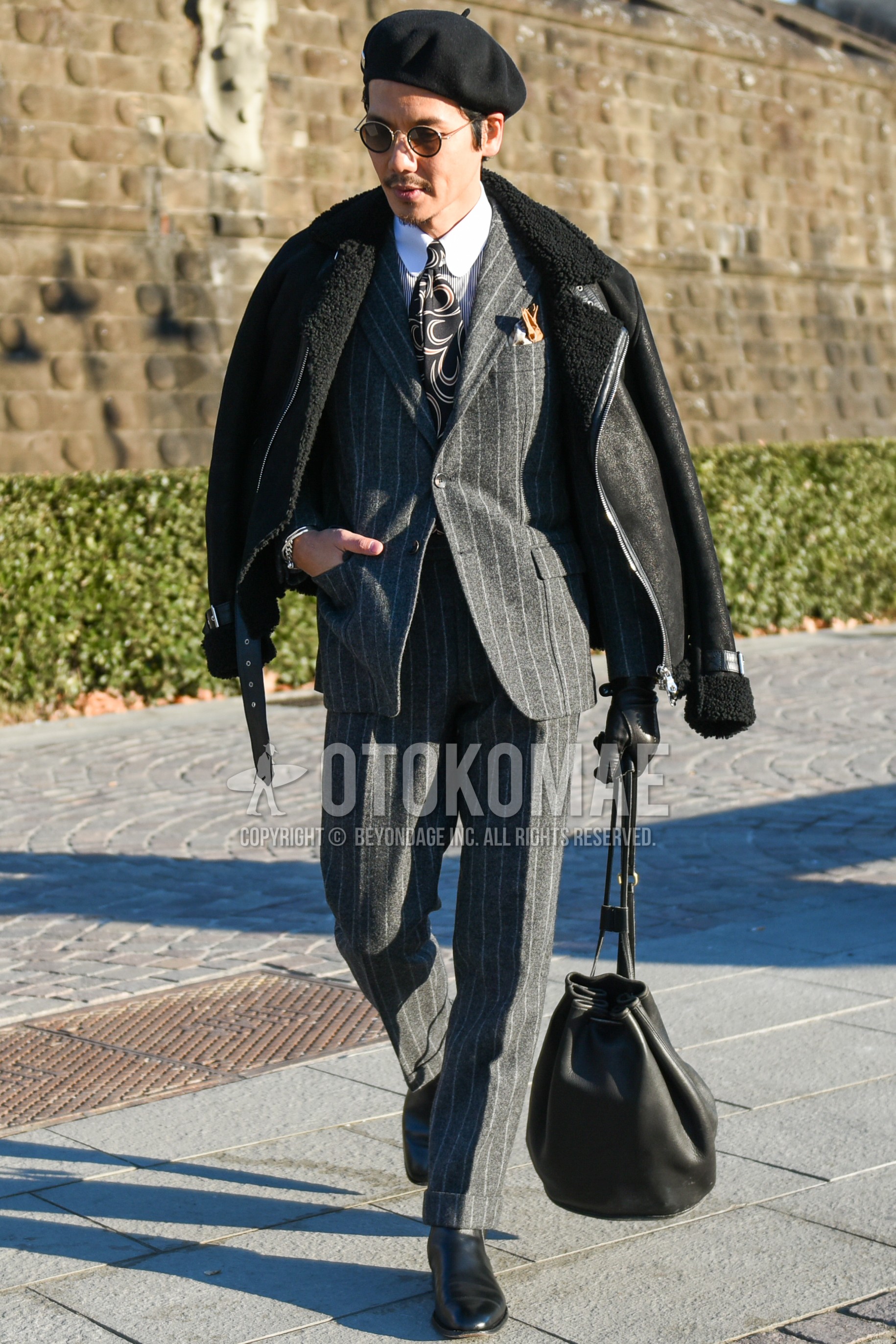 Men's autumn winter outfit with black plain leather jacket, white plain shirt, black  boots, black plain briefcase/handbag, gray stripes suit, black necktie necktie.