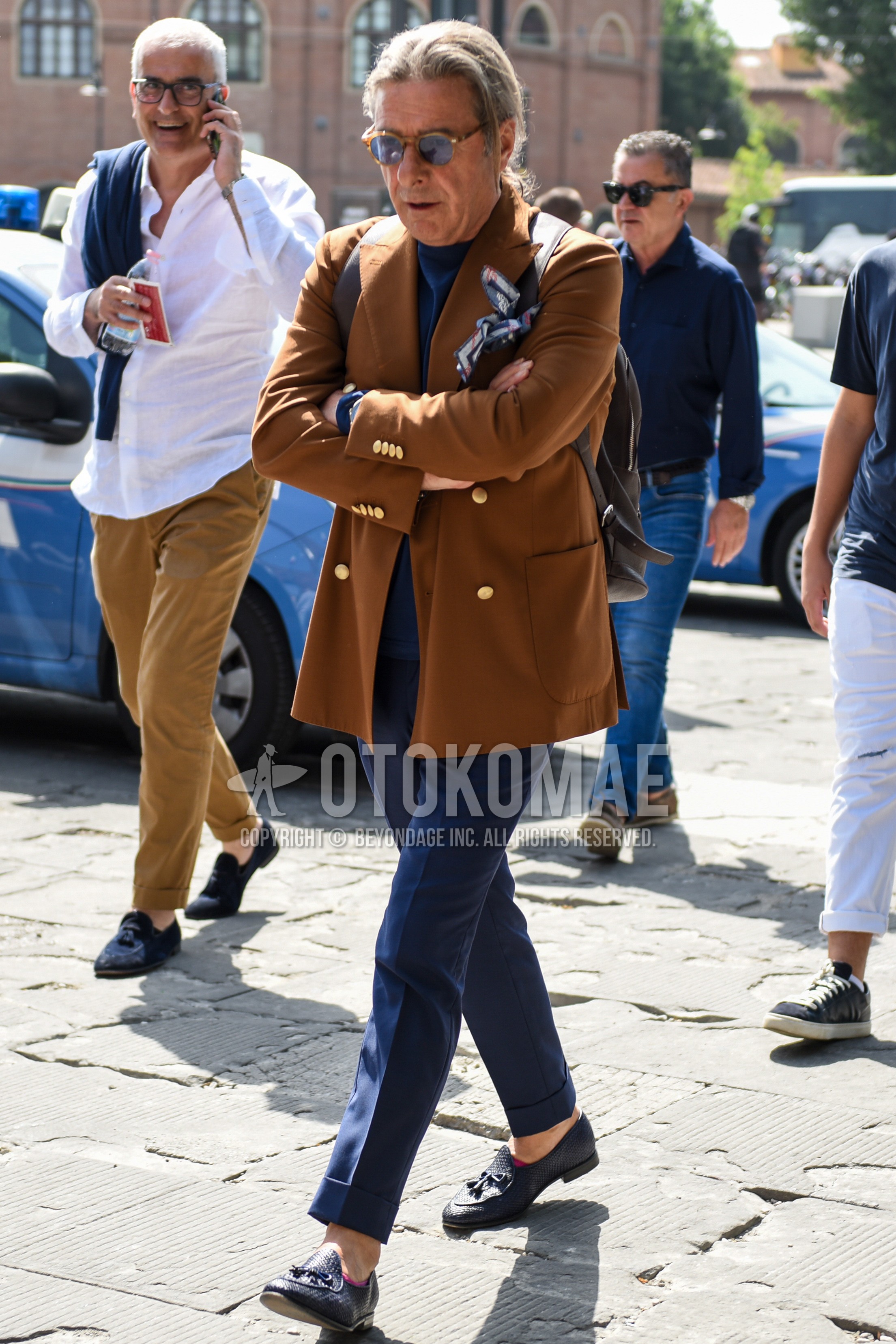Men's spring summer autumn outfit with brown plain sunglasses, brown plain tailored jacket, blue plain sweater, navy plain slacks, navy tassel loafers leather shoes.