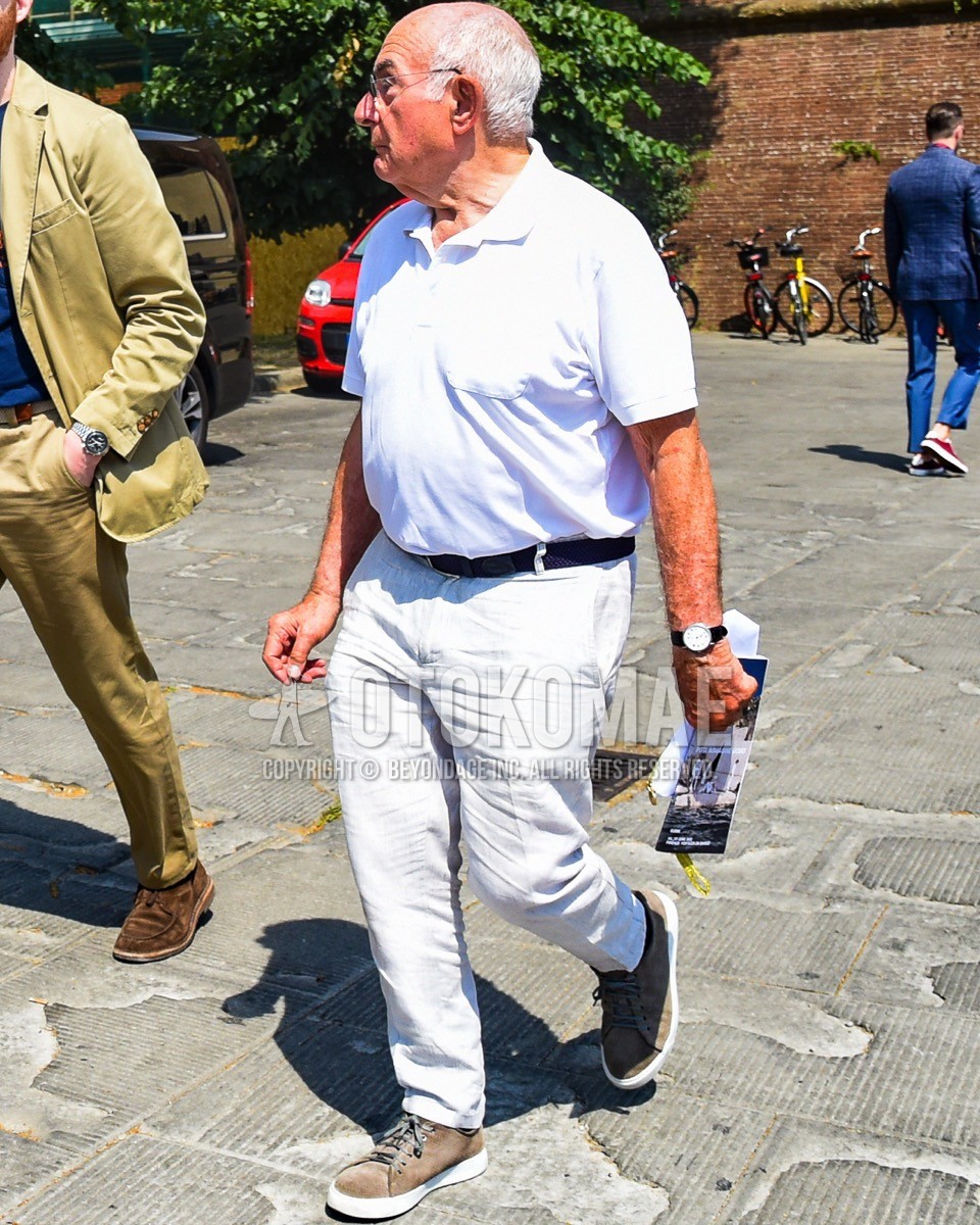 Men's spring summer outfit with silver plain glasses, white plain polo shirt, navy plain braided belt, white plain cotton pants, brown low-cut sneakers.