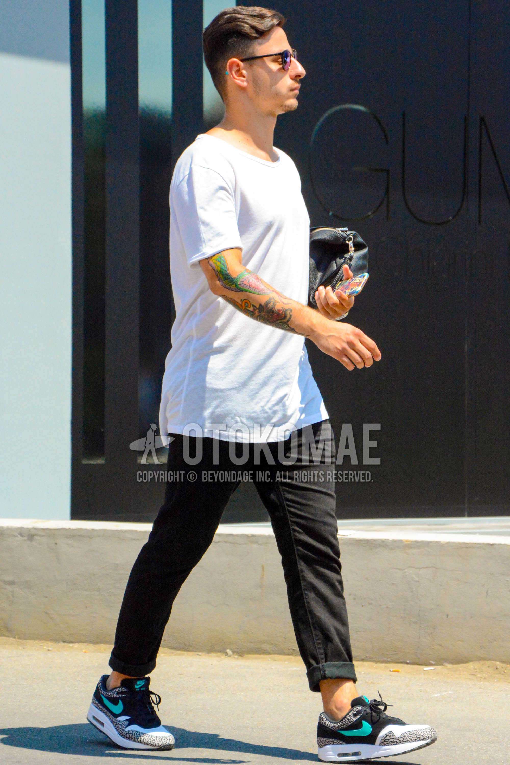 Men's summer outfit with plain sunglasses, white plain t-shirt, black plain denim/jeans, black sneakers.