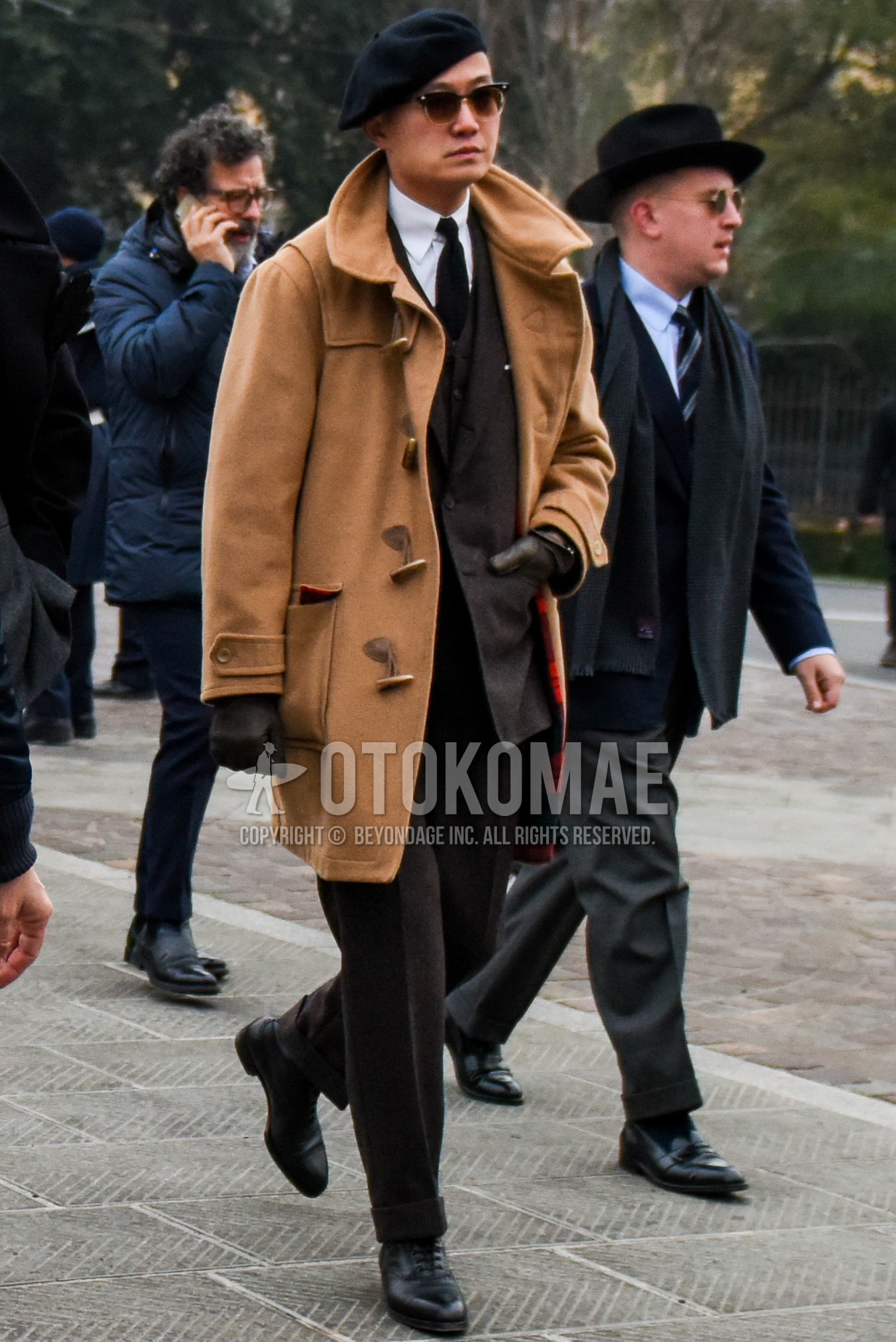 Men's winter outfit with black plain cap, black plain sunglasses, beige plain duffle coat, white plain shirt, black plain toe leather shoes, brown plain three-piece suit, black plain necktie.