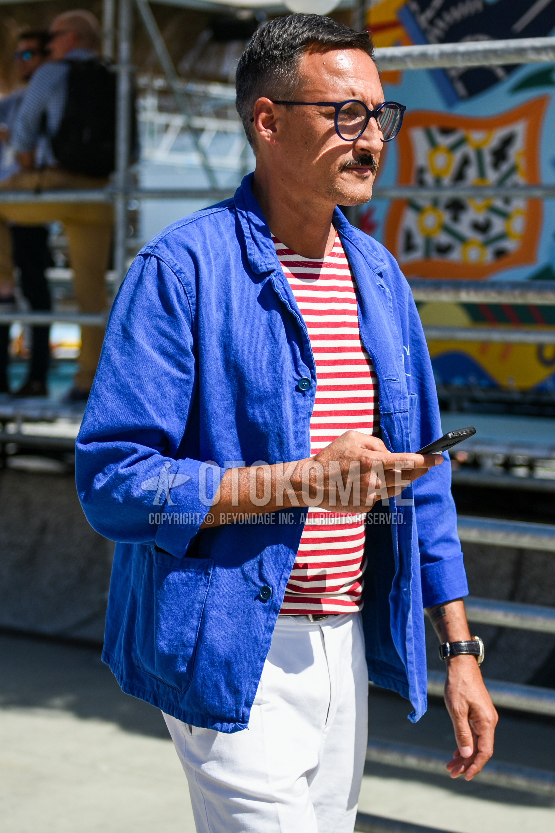 Men's spring outfit with blue plain glasses, blue plain shirt jacket, red white horizontal stripes t-shirt, white plain cotton pants.