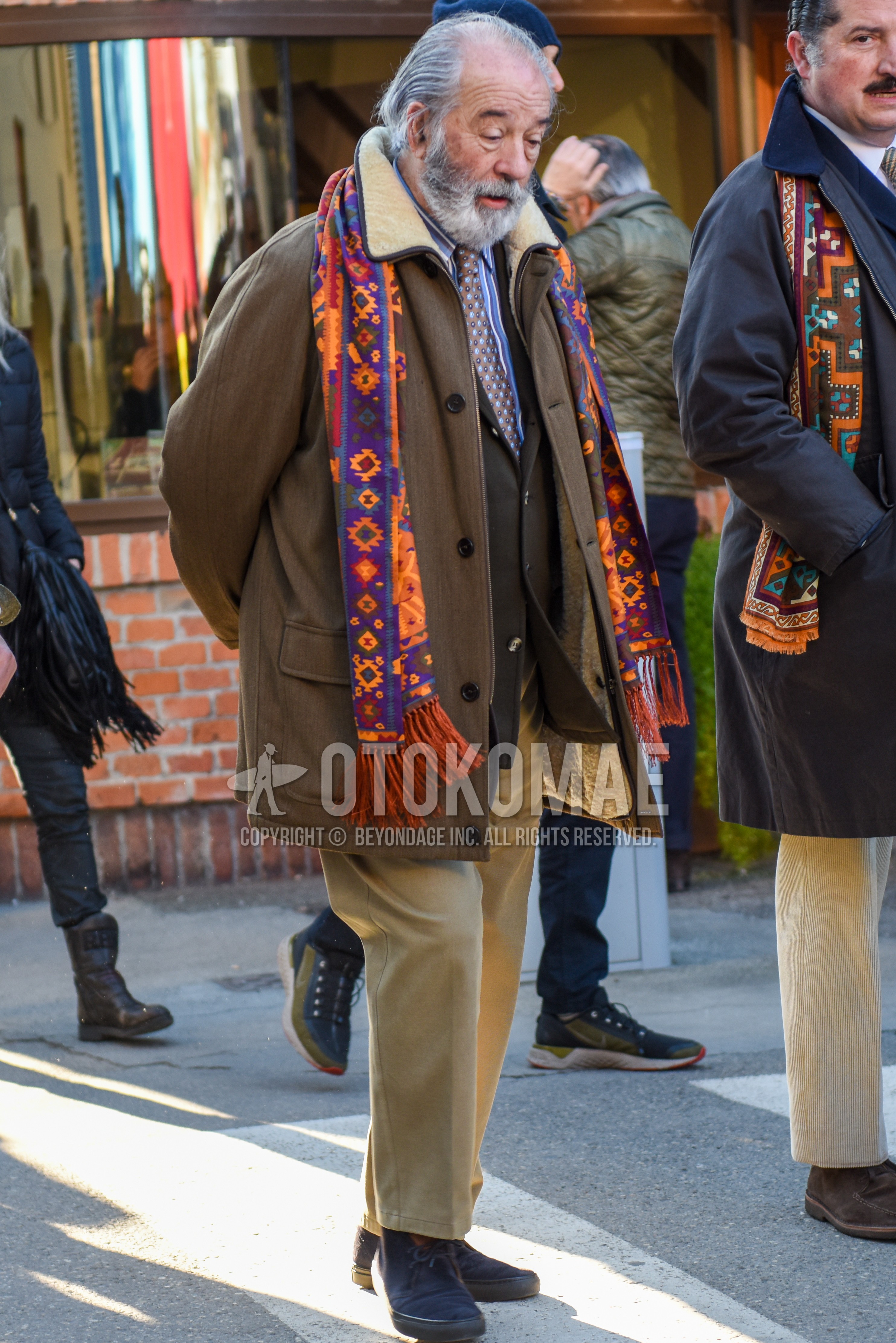 Men's autumn winter outfit with multi-color scarf scarf, brown plain outerwear, gray plain tailored jacket, light blue stripes shirt, beige plain chinos, navy  boots, brown necktie necktie.