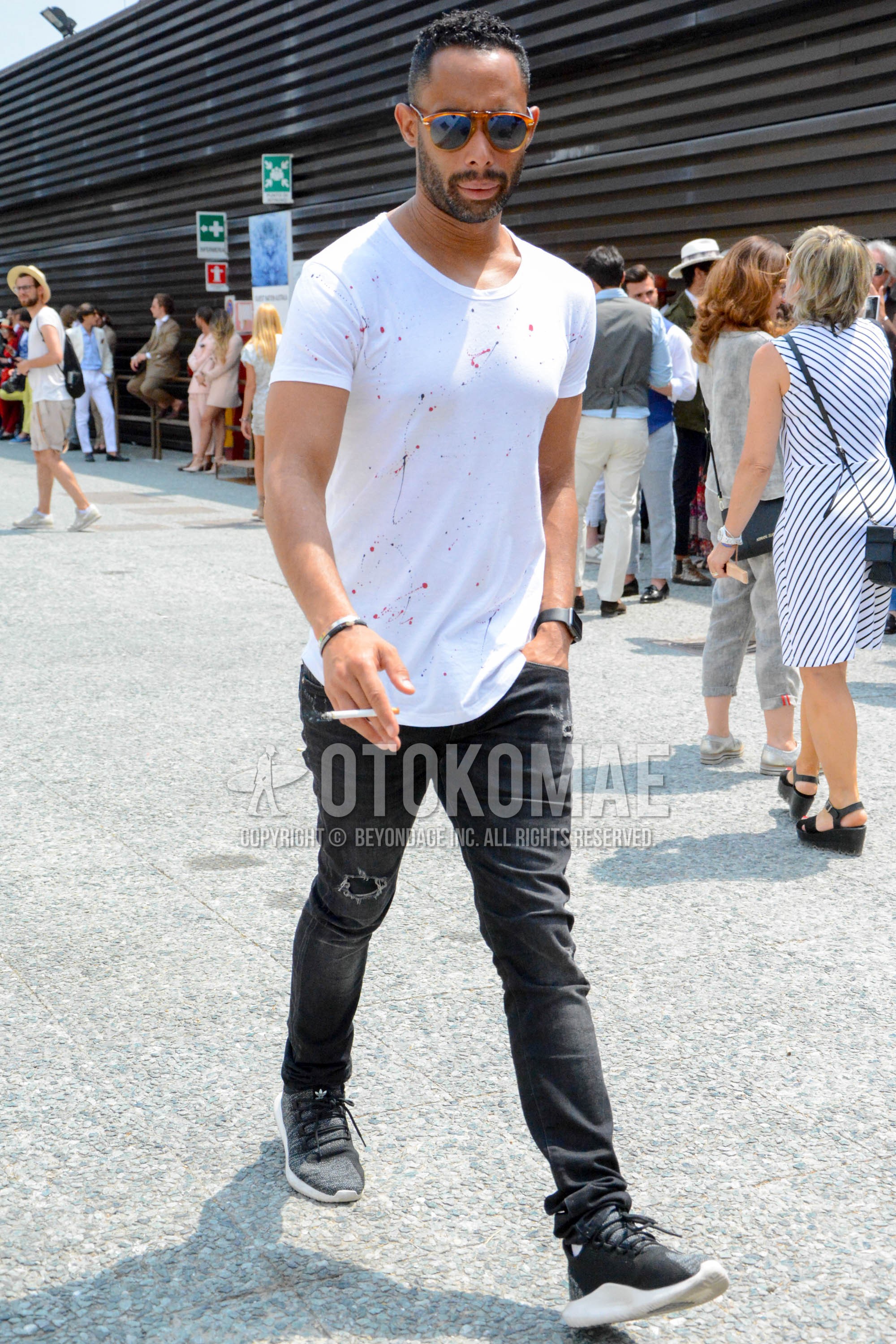 Men's spring summer outfit with brown tortoiseshell sunglasses, white tops/innerwear t-shirt, dark gray plain damaged jeans, black low-cut sneakers.
