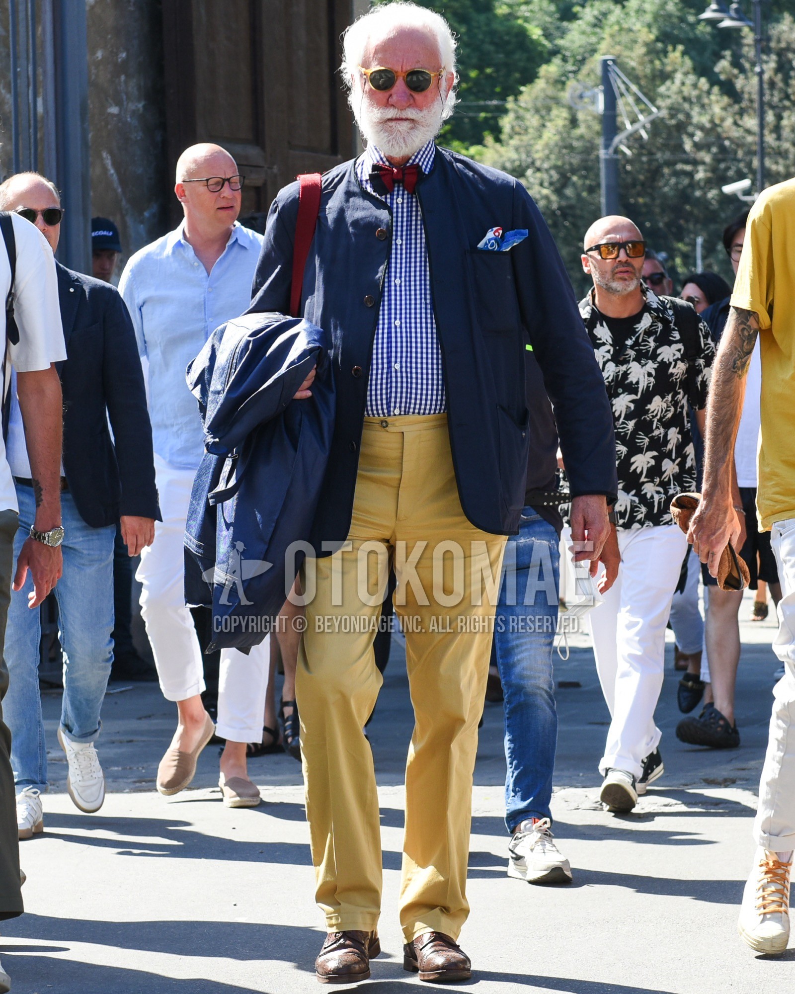 Men's spring summer outfit with yellow plain sunglasses, navy plain military jacket, white blue check shirt, yellow plain slacks, brown brogue shoes leather shoes, red plain necktie.