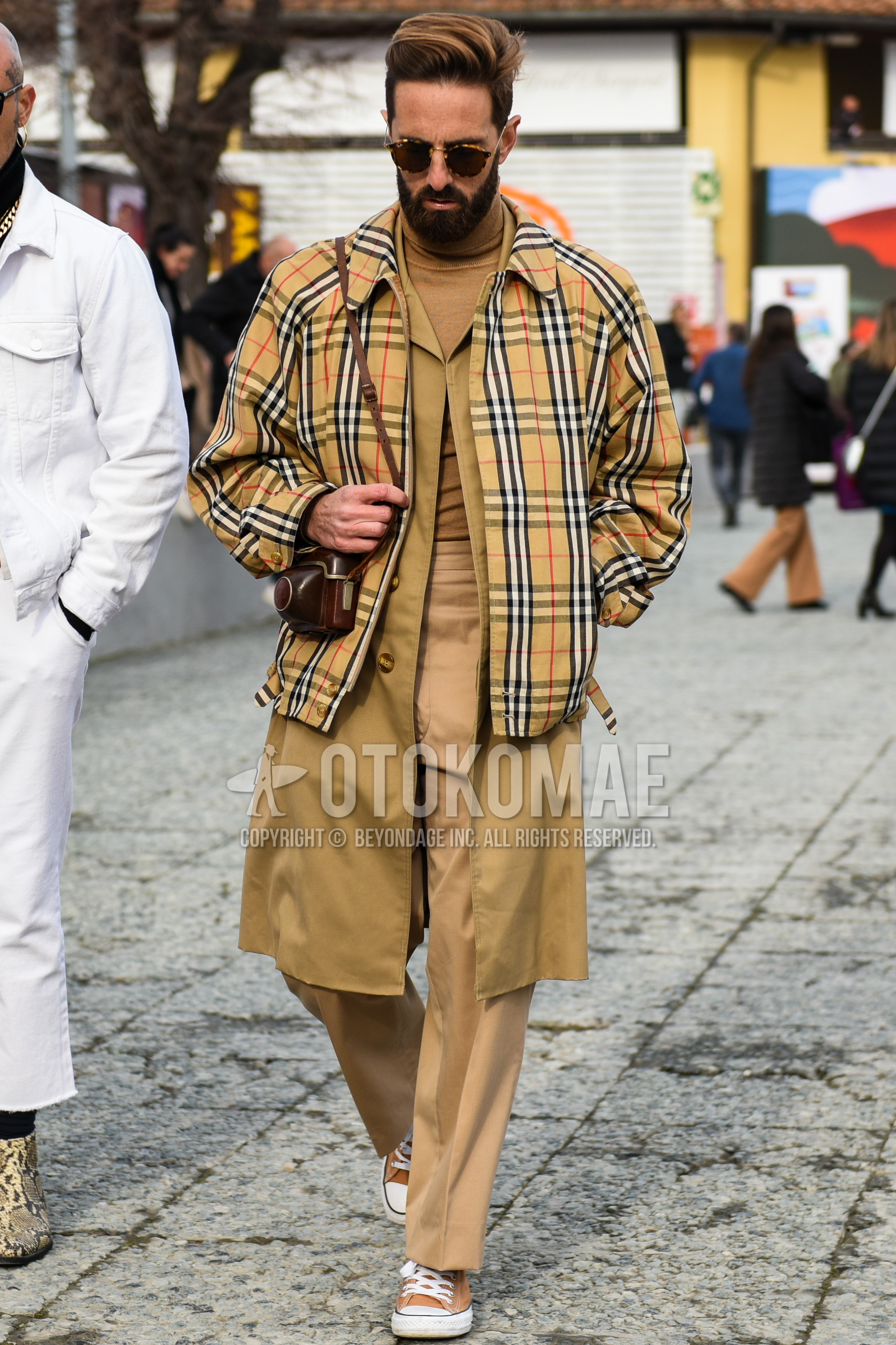 Men's autumn winter outfit with beige check outerwear, beige plain stenkarrer coat, beige plain turtleneck knit, beige plain chinos, brown high-cut sneakers.