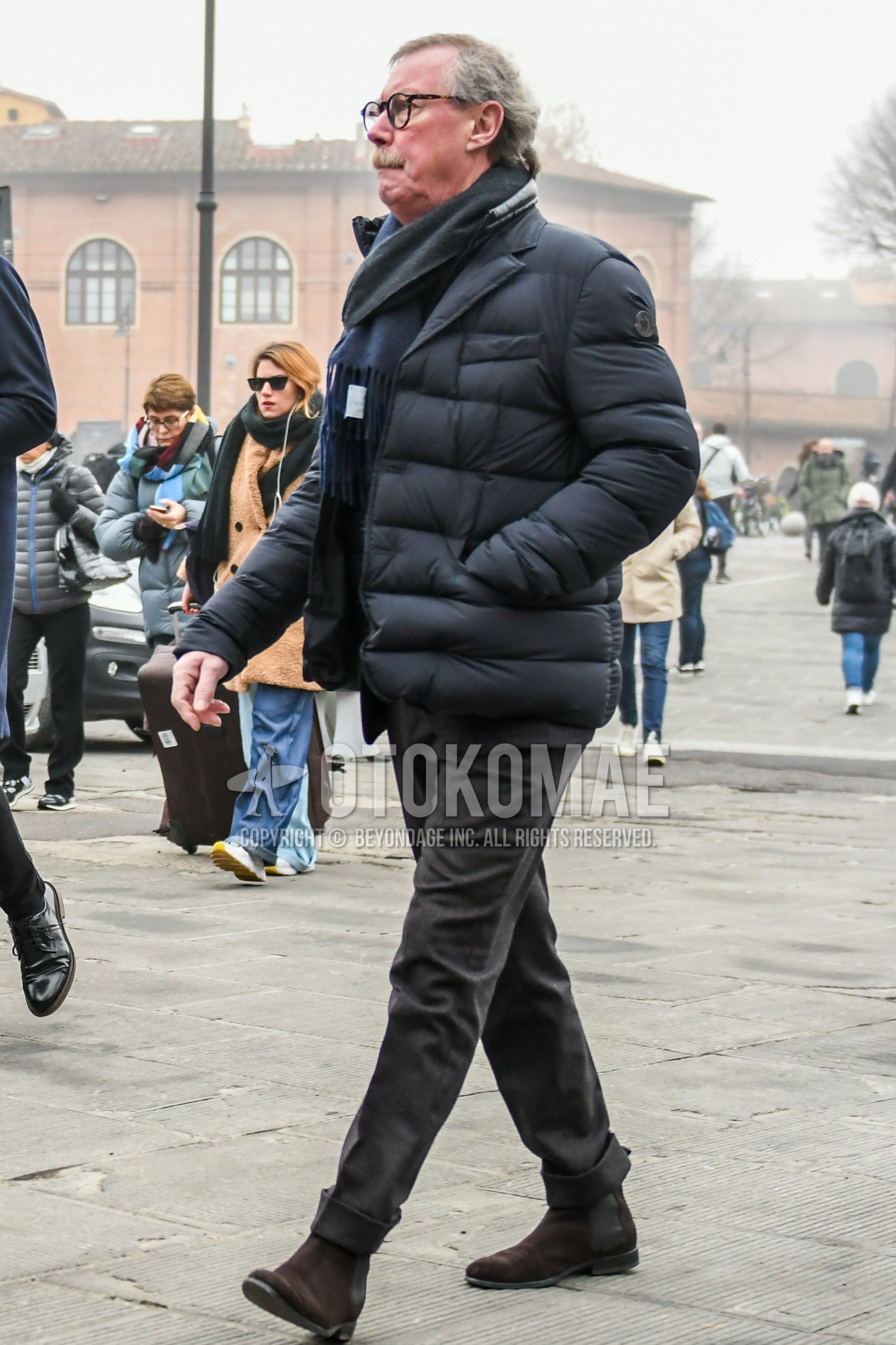 Men's winter outfit with plain glasses, gray plain scarf, black plain down jacket, gray plain slacks, brown side-gore boots.