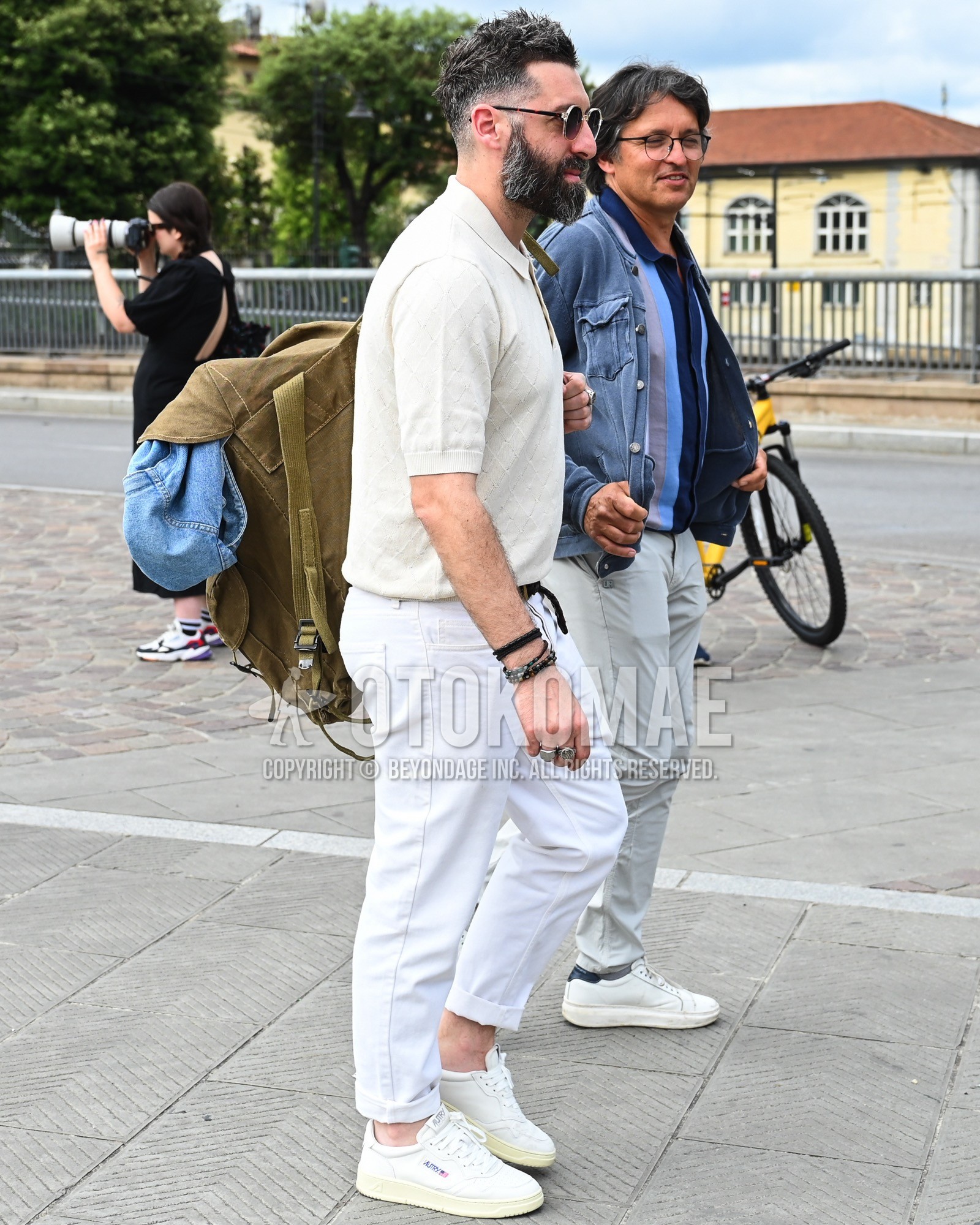Men's spring summer outfit with black plain sunglasses, white plain polo shirt, white plain denim/jeans, white low-cut sneakers.