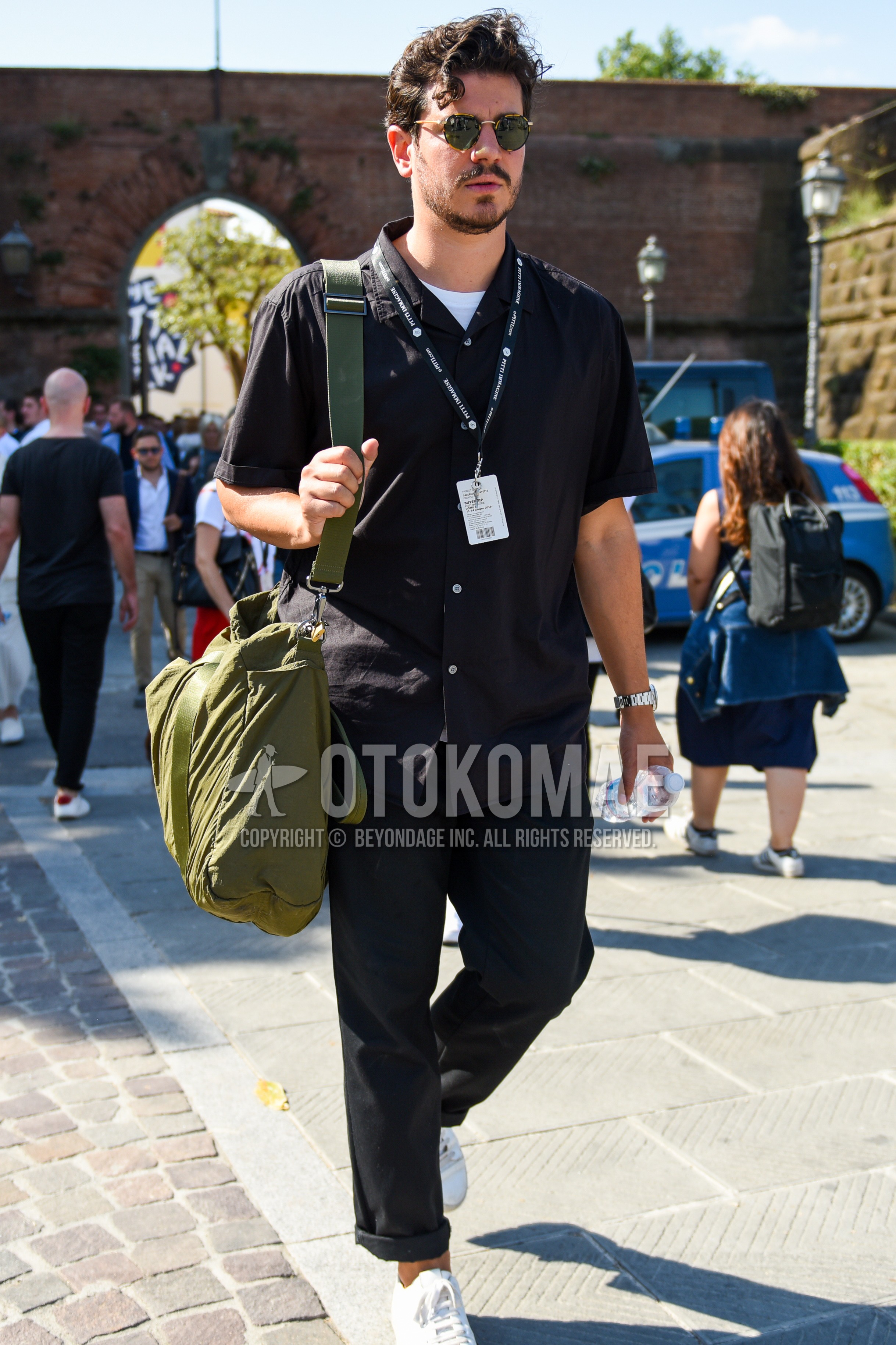 Men's summer outfit with black plain sunglasses, black plain shirt, black plain cotton pants, olive green plain shoulder bag.