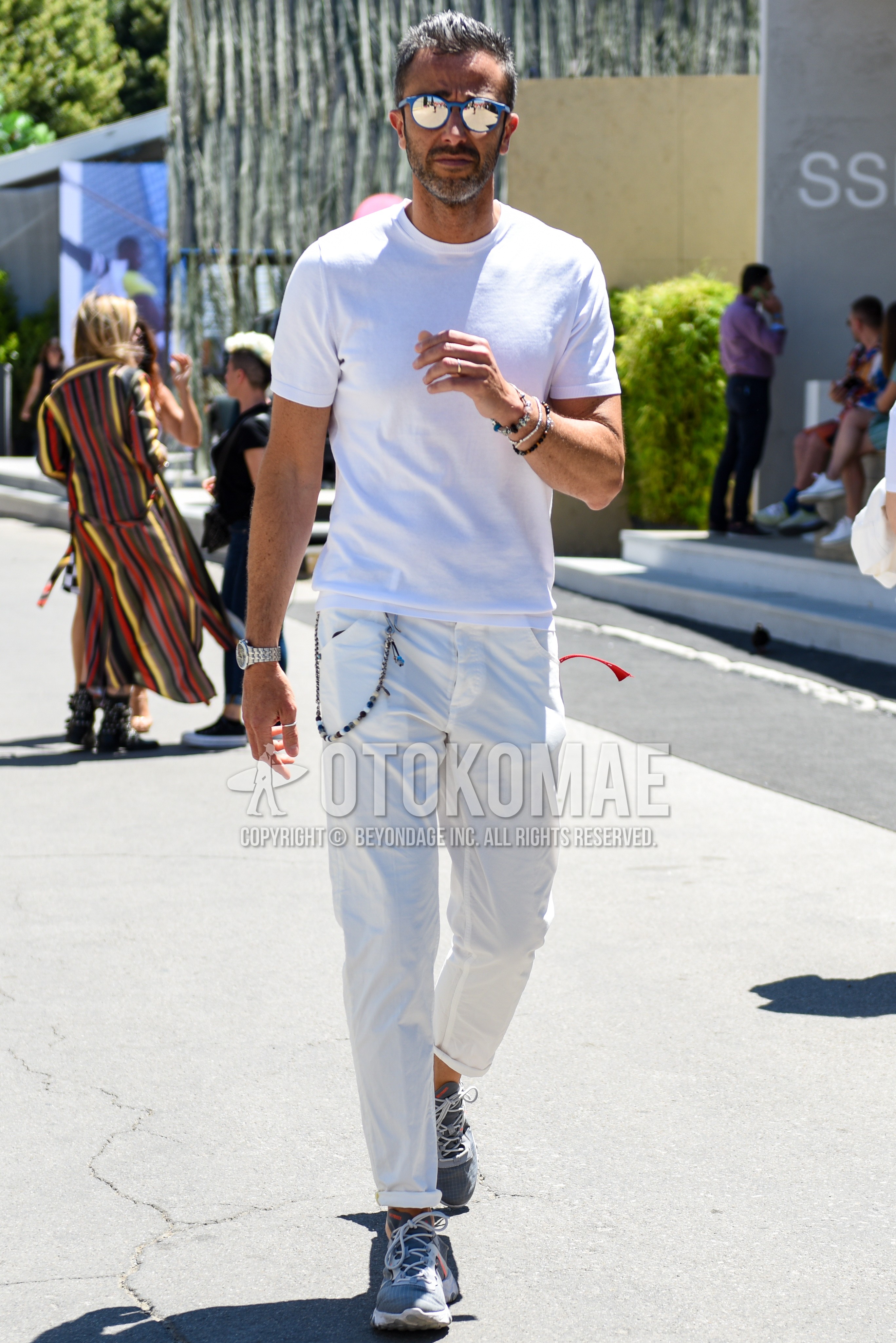 Men's summer outfit with gray plain sunglasses, white plain t-shirt, white plain cotton pants, gray low-cut sneakers.