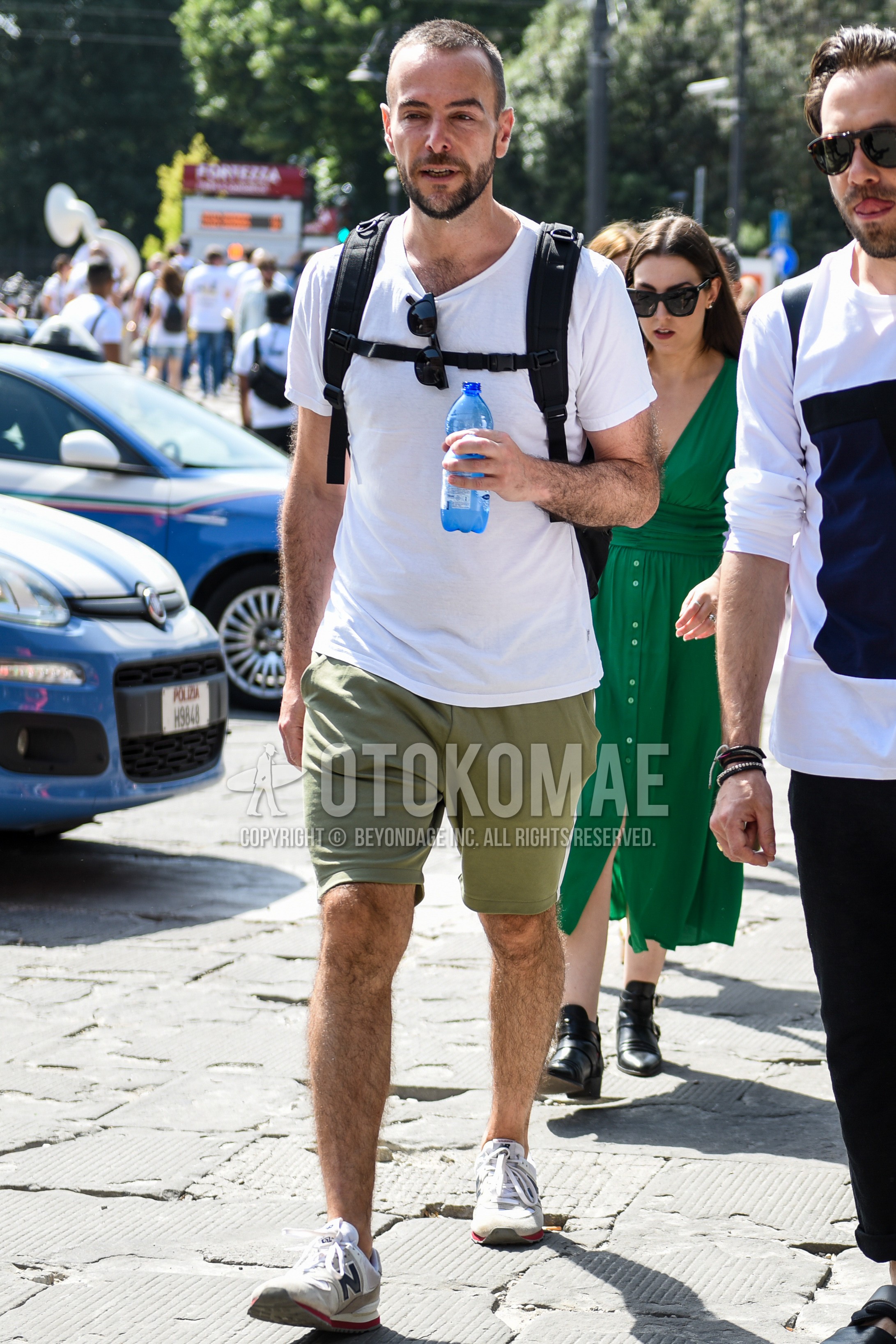 Men's summer outfit with white plain t-shirt, green plain short pants, white low-cut sneakers.
