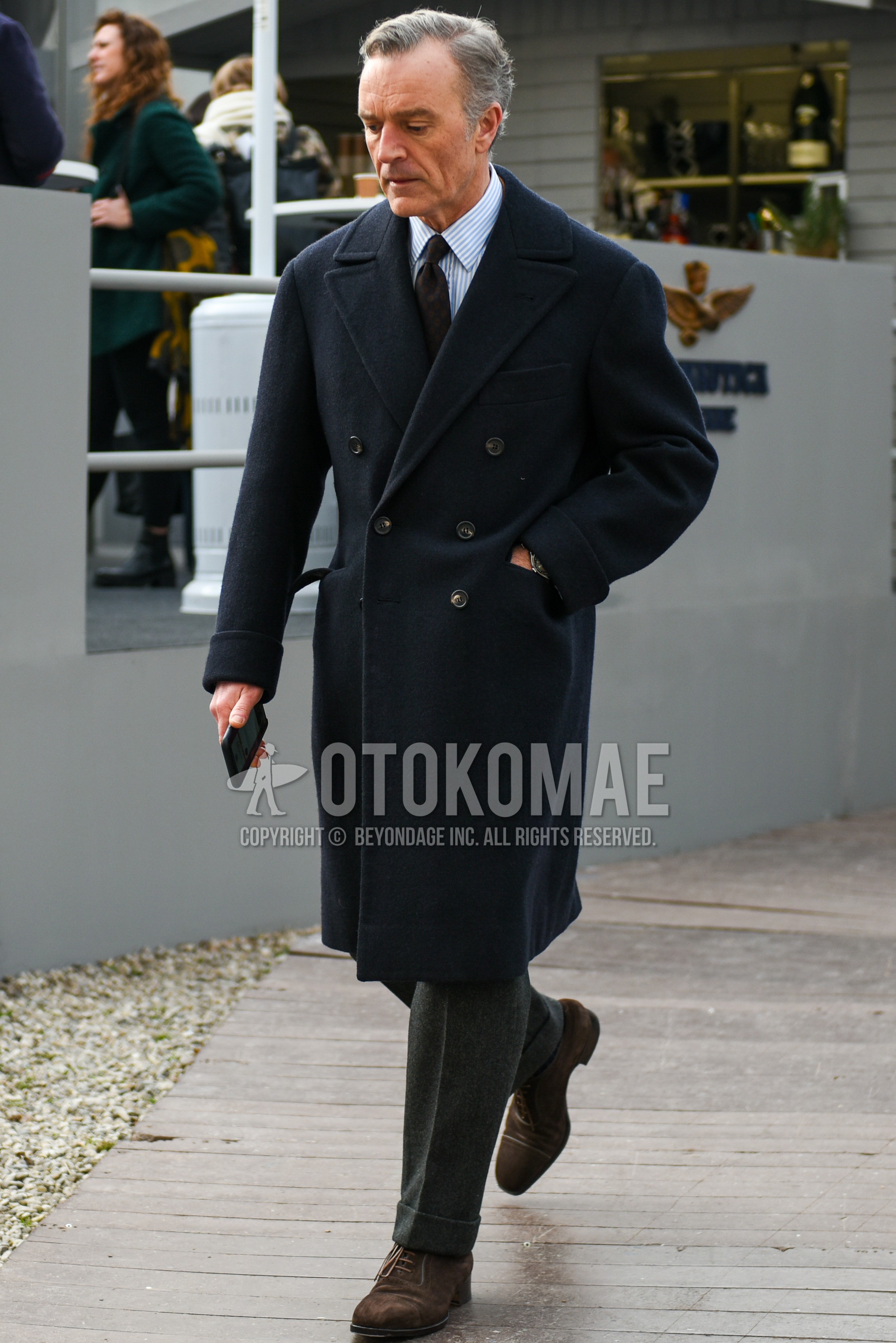 Men's autumn winter outfit with black plain chester coat, light blue stripes shirt, gray plain slacks, brown straight-tip shoes leather shoes, brown navy necktie necktie.