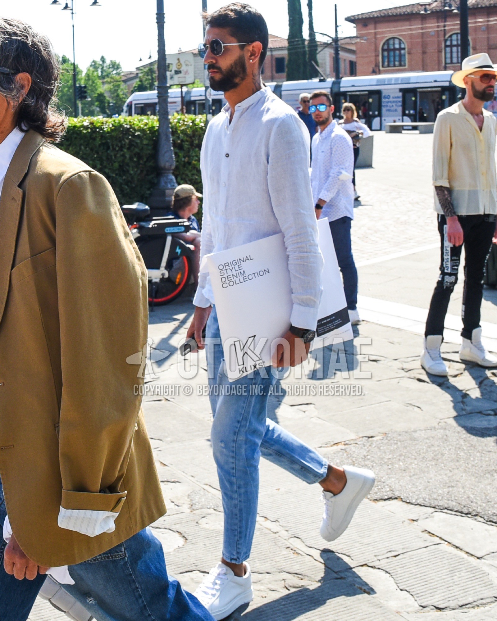 Men's spring summer outfit with silver plain sunglasses, white plain shirt, blue plain denim/jeans, white low-cut sneakers.