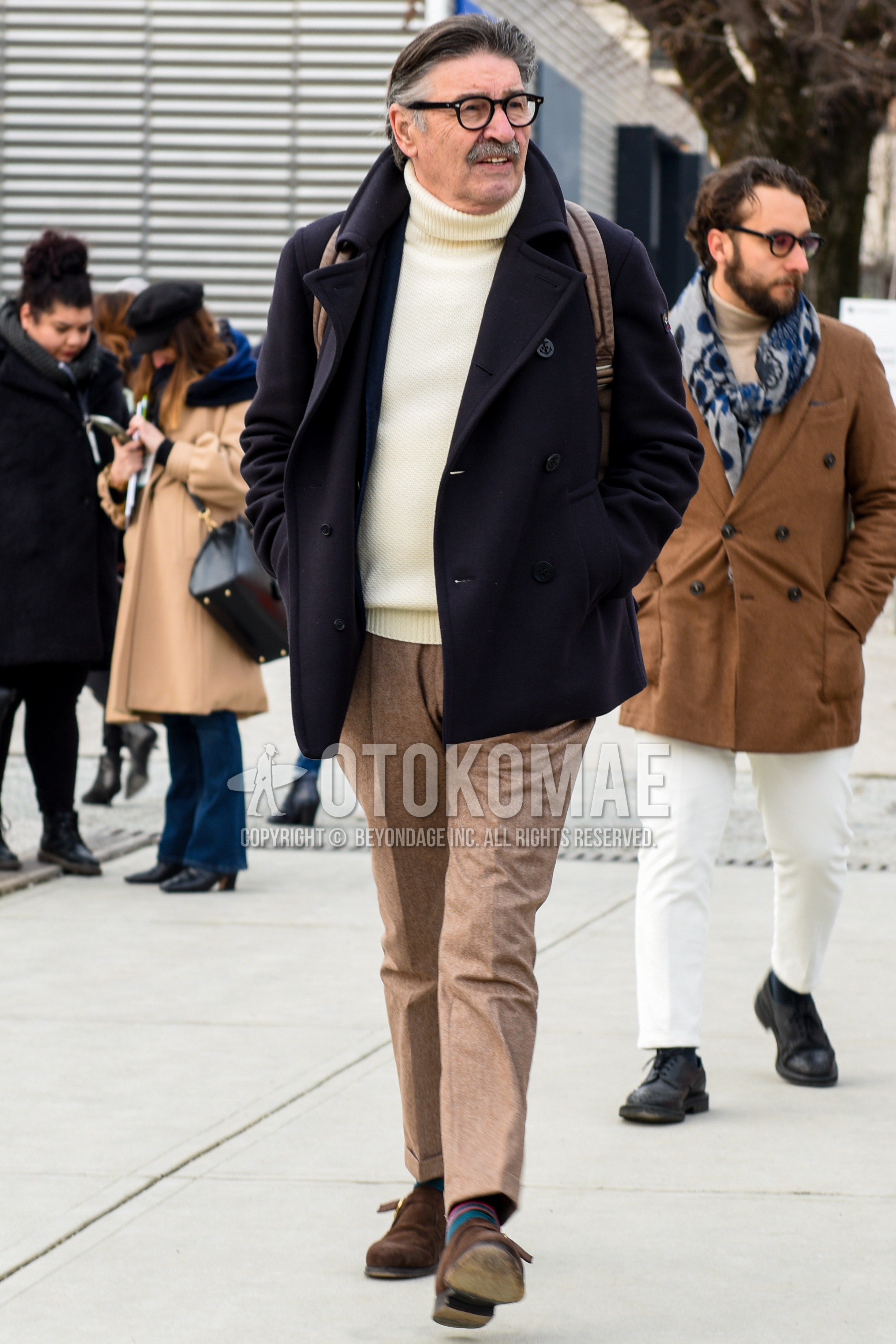 Men's autumn winter outfit with black plain glasses, black plain p coat, white plain turtleneck knit, beige plain slacks, beige plain ankle pants, multi-color horizontal stripes socks, brown monk shoes leather shoes.