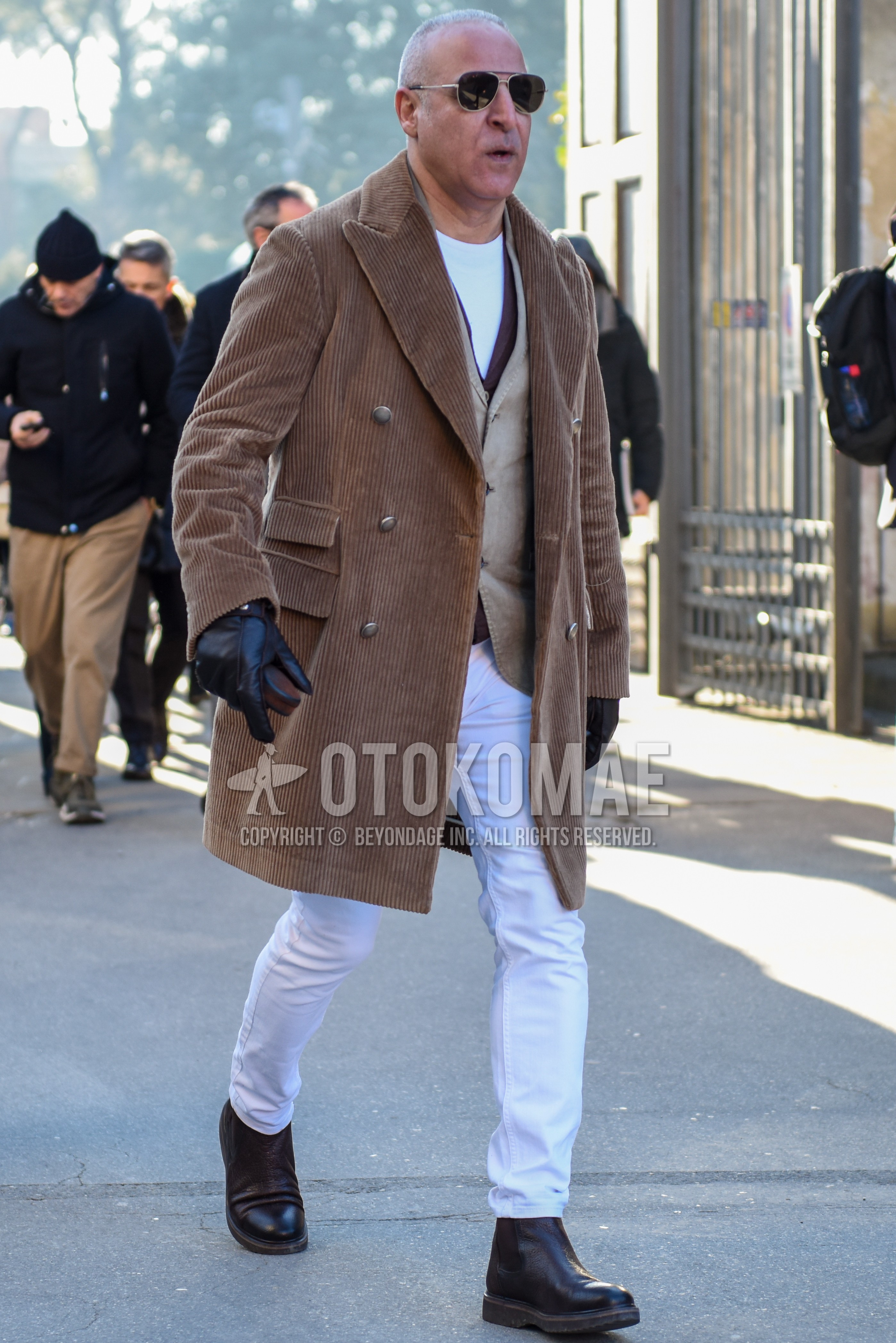 Men's autumn winter outfit with silver plain sunglasses, beige plain chester coat, beige plain gilet, white plain t-shirt, white plain cotton pants, brown side-gore boots.