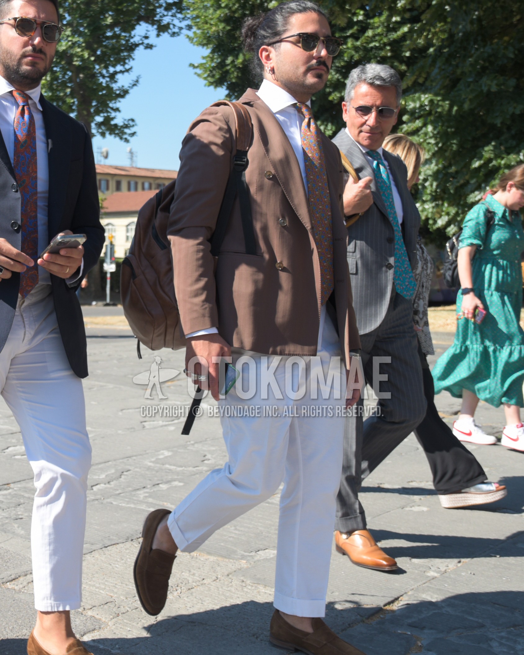 Men's spring summer autumn outfit with black tortoiseshell sunglasses, brown plain tailored jacket, white plain shirt, white plain slacks, brown coin loafers leather shoes, brown plain backpack, brown small crest necktie.