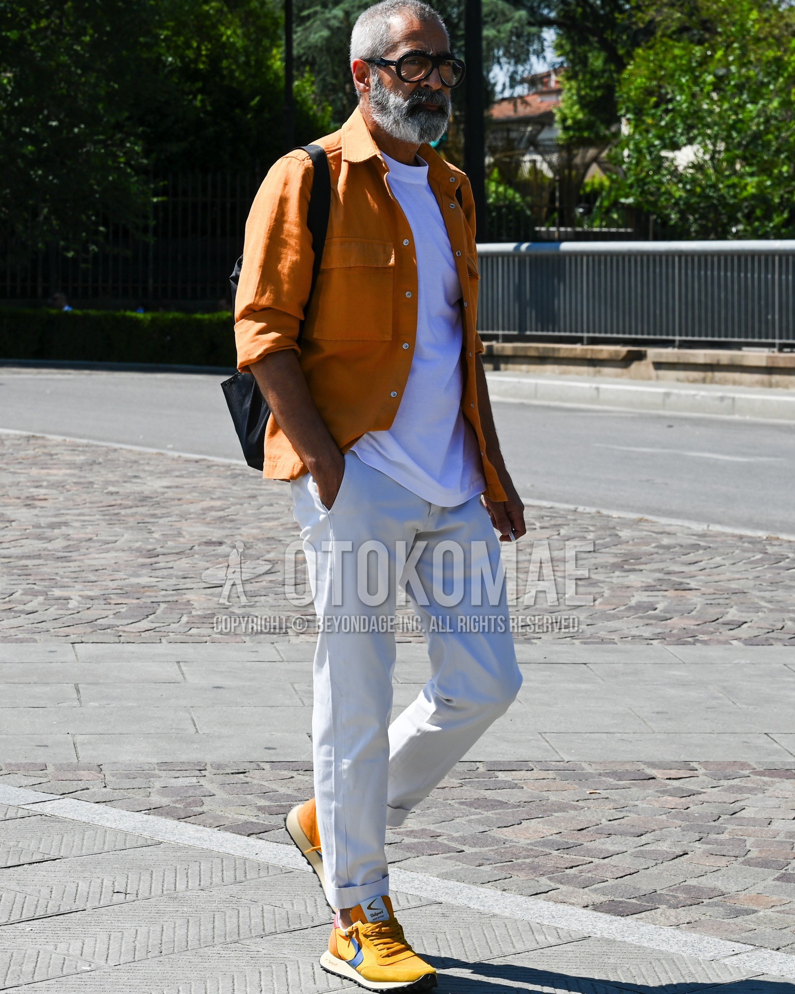 Men's spring summer autumn outfit with brown plain coverall, white plain t-shirt, white plain slacks, yellow low-cut sneakers, black plain shoulder bag.