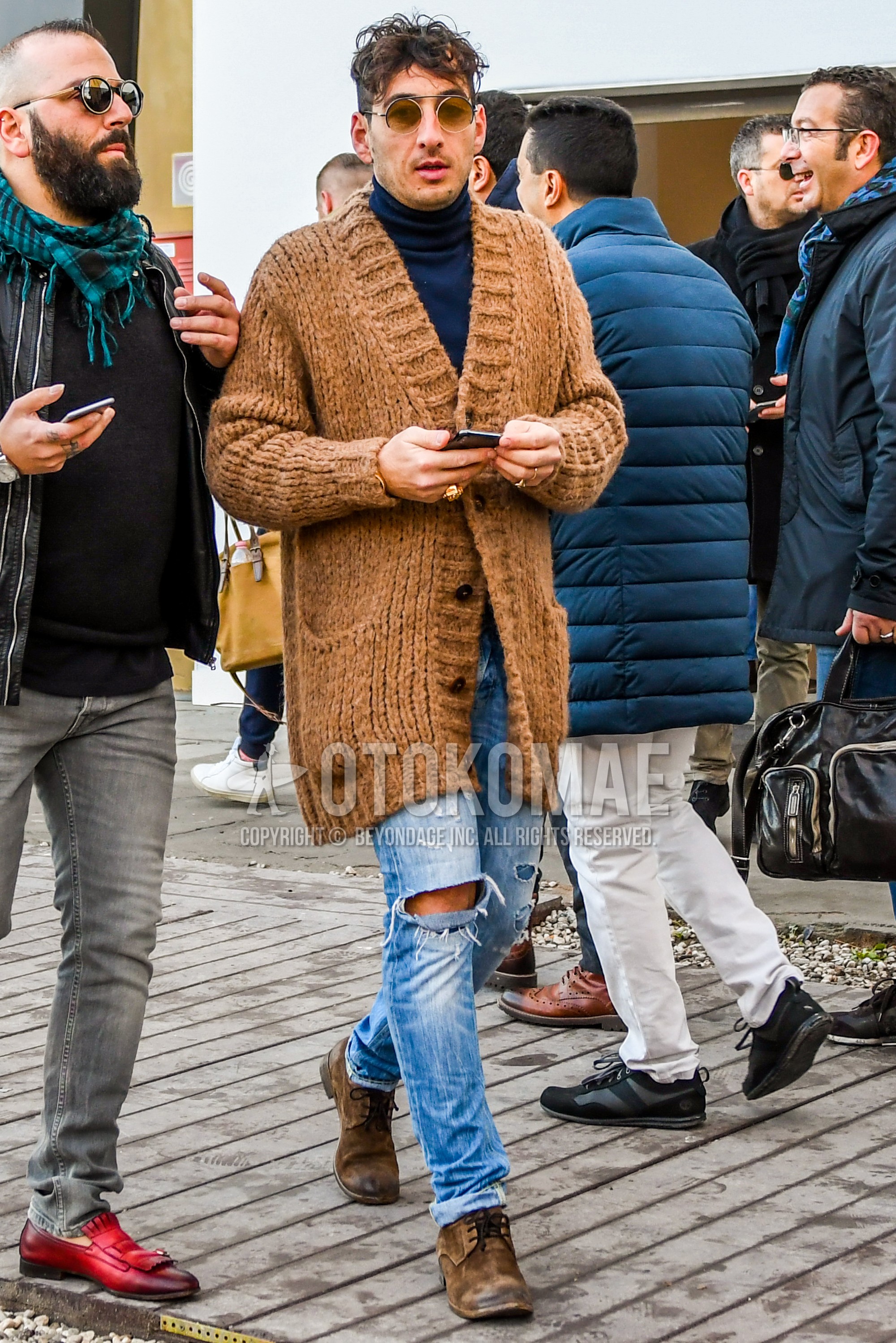 Men's autumn winter outfit with plain sunglasses, brown plain cardigan, gray plain turtleneck knit, light blue plain damaged jeans, brown plain toe leather shoes.