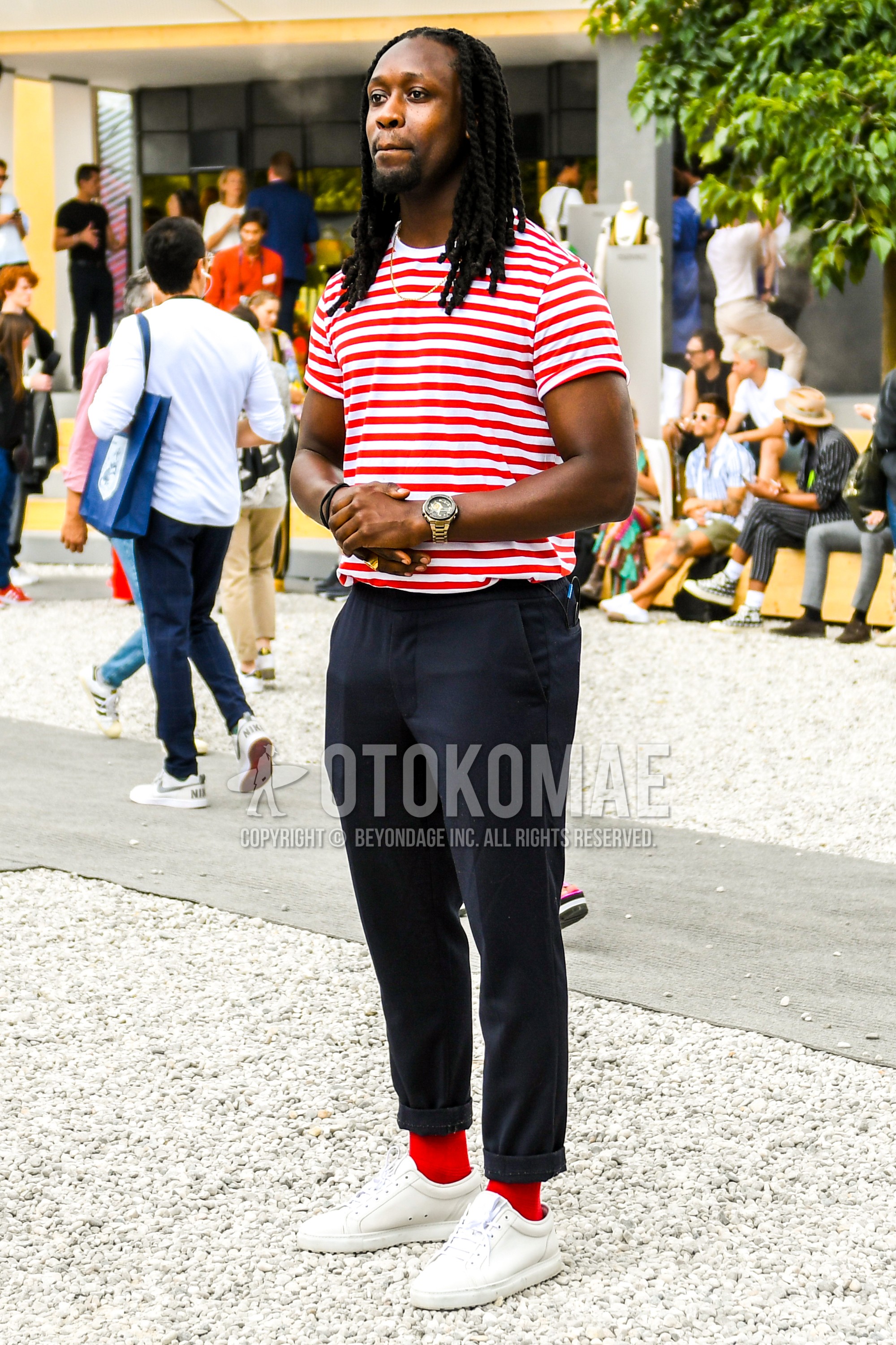 Men's summer outfit with white red horizontal stripes t-shirt, black plain cotton pants, red plain socks, white low-cut sneakers.
