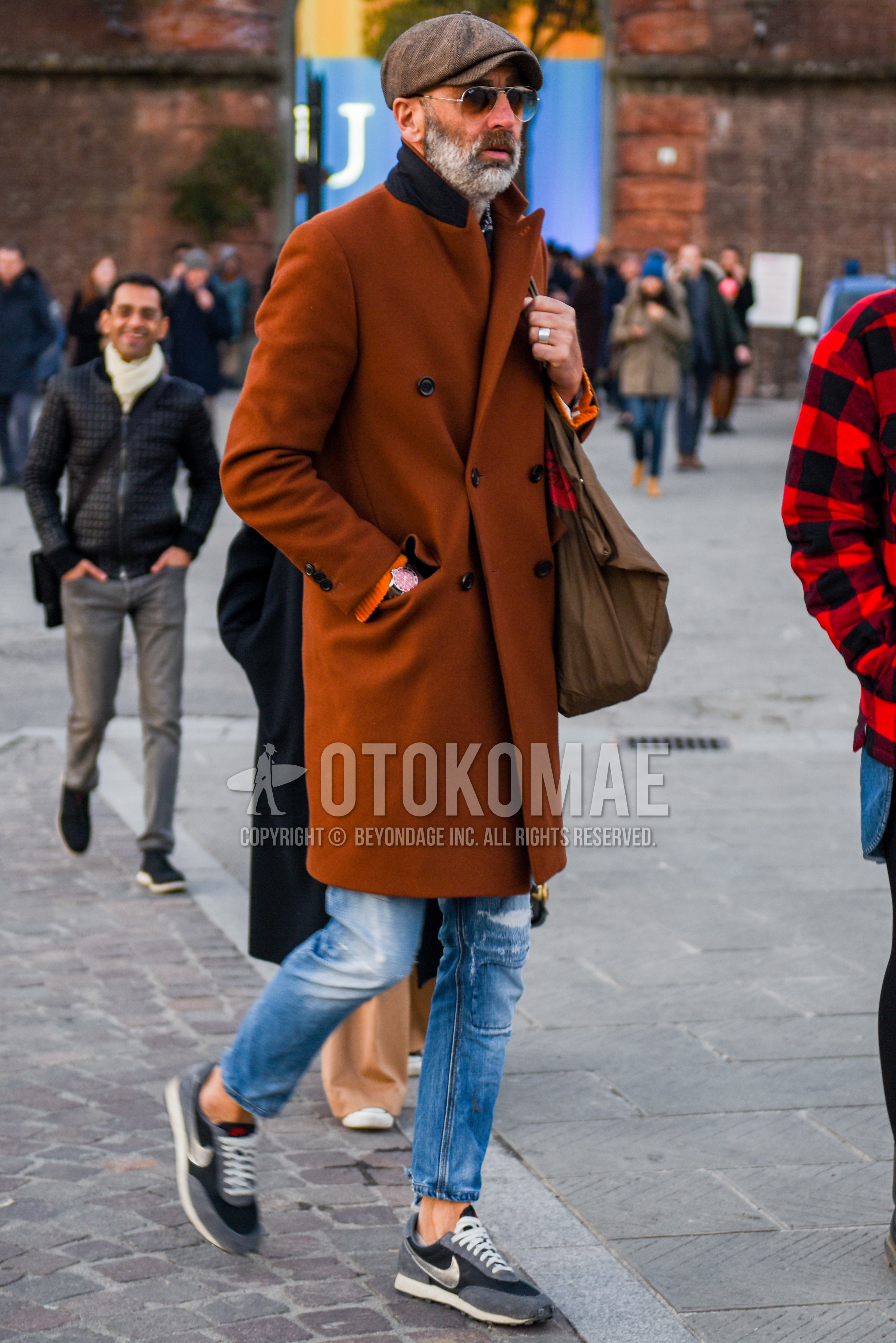 Men's autumn winter outfit with brown plain hunting cap, silver plain sunglasses, brown plain chester coat, blue plain denim/jeans, gray low-cut sneakers.