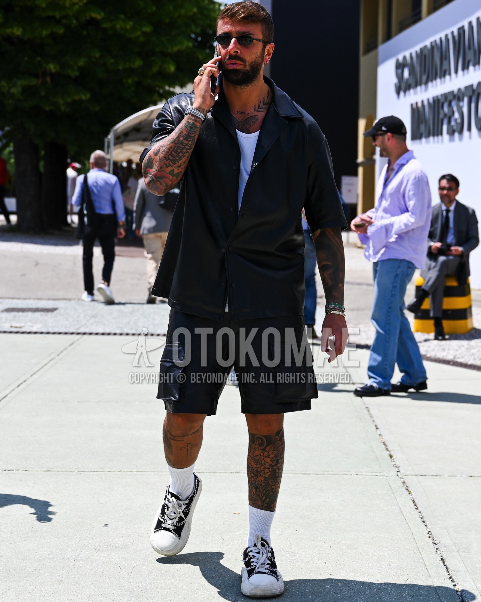 Men's spring summer outfit with black plain sunglasses, black plain shirt, white plain t-shirt, black plain short pants, white plain socks, black low-cut sneakers.