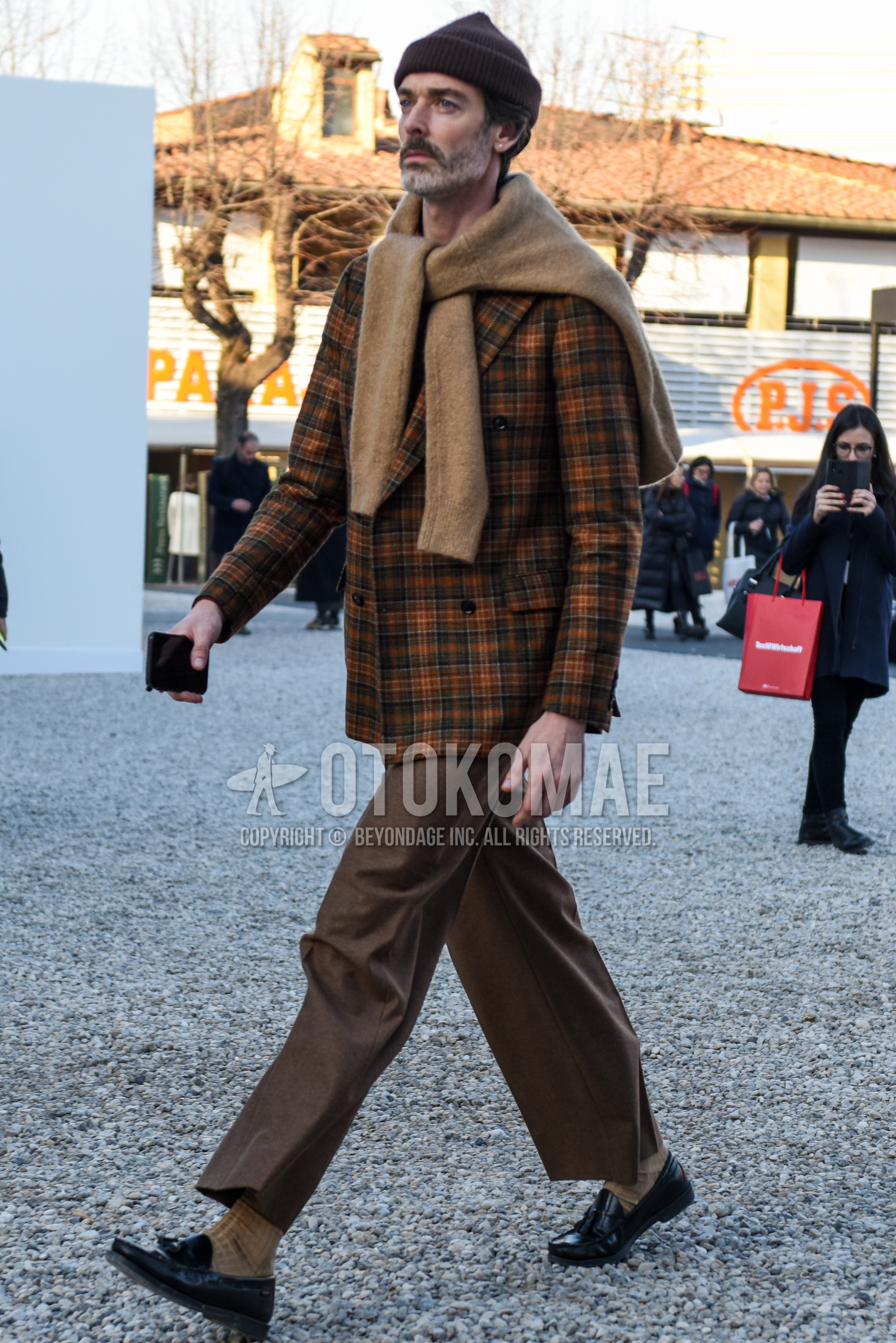 Men's spring autumn outfit with brown plain knit cap, beige plain sweater, brown check tailored jacket, brown plain slacks, brown plain ankle pants, beige plain socks, black tassel loafers leather shoes.