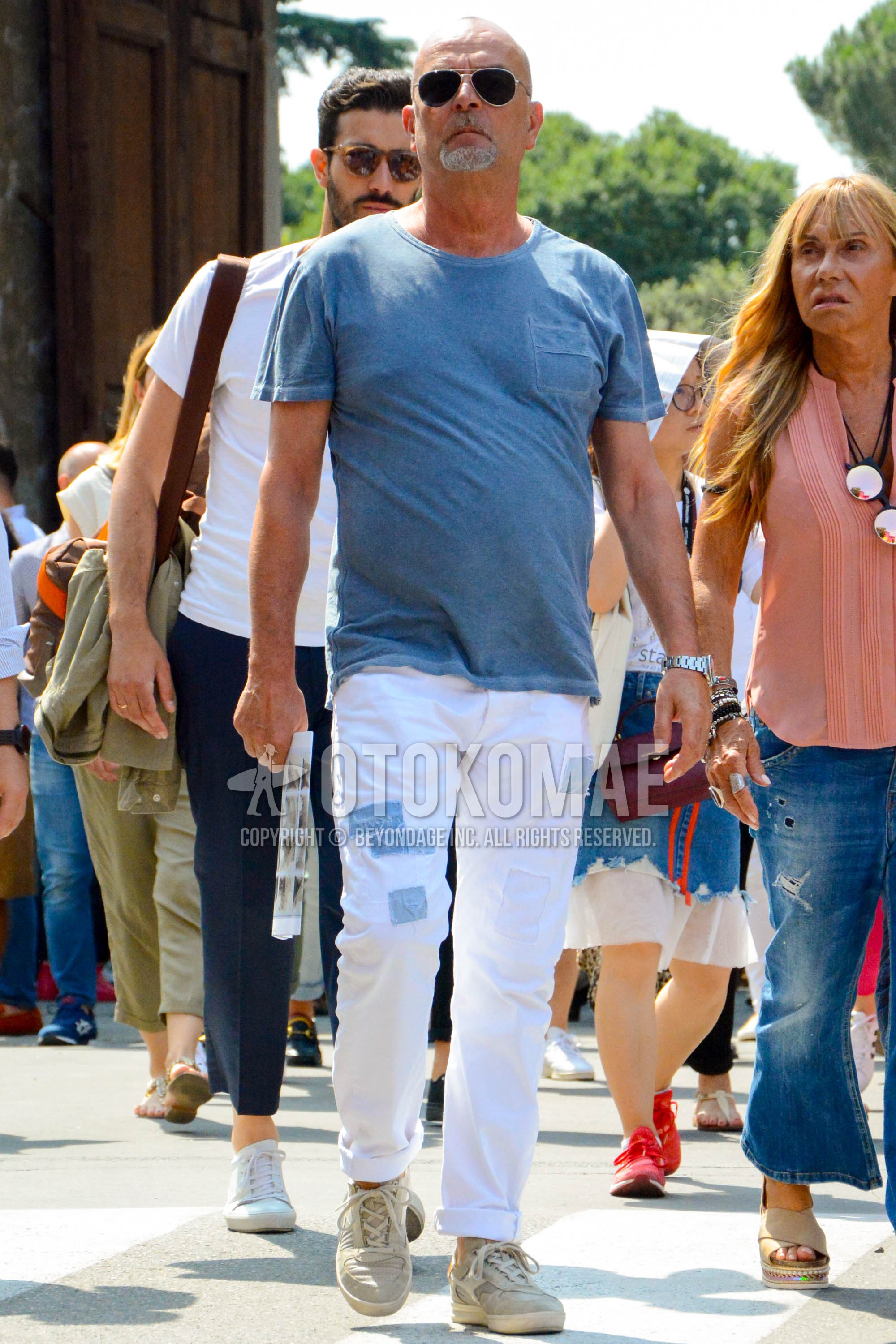 Men's spring summer outfit with silver plain sunglasses, blue plain t-shirt, white plain damaged jeans, gray low-cut sneakers.