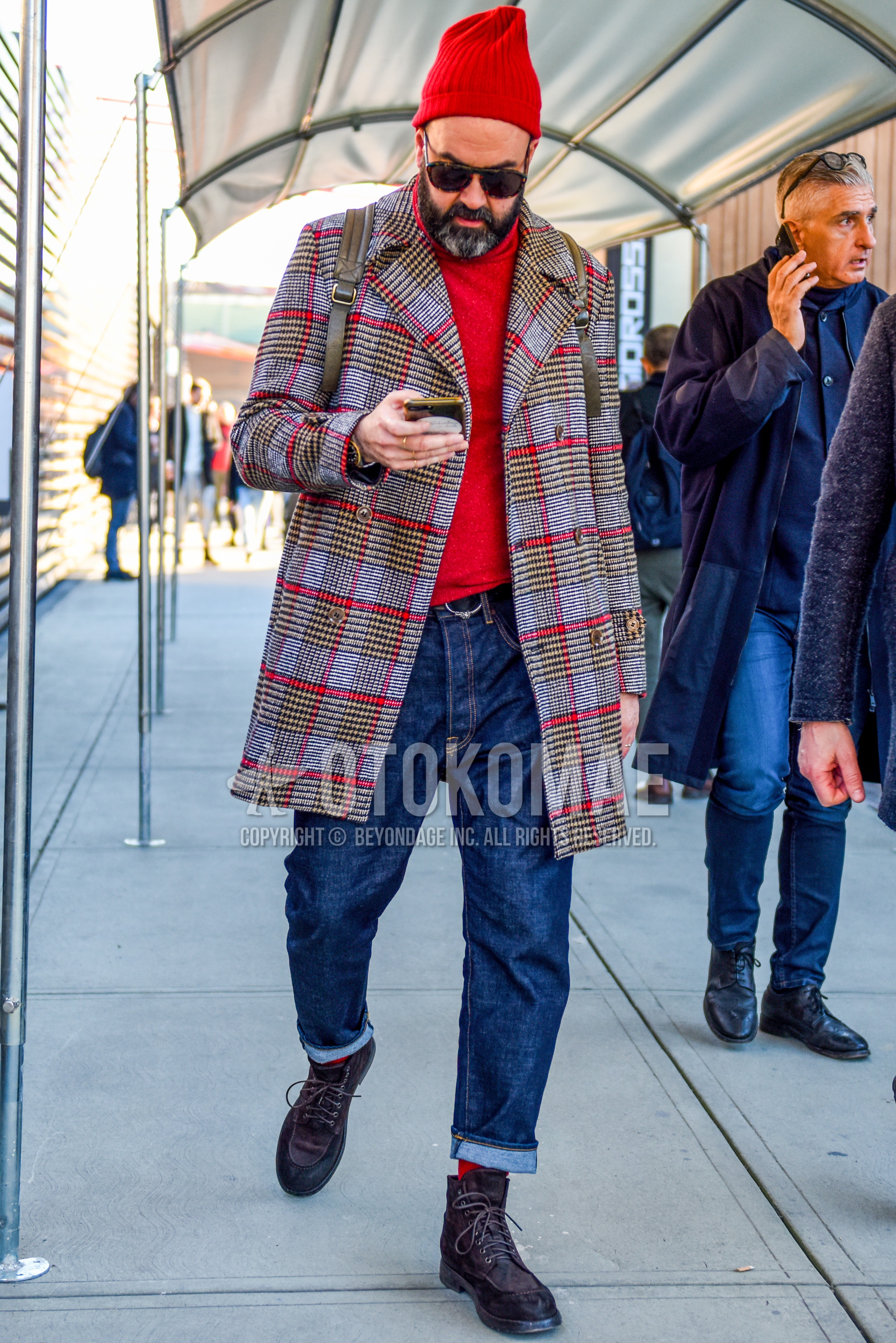 Men's autumn winter outfit with red plain knit cap, brown tortoiseshell sunglasses, gray check ulster coat, red plain turtleneck knit, black plain leather belt, blue plain denim/jeans, red plain socks, brown  boots.