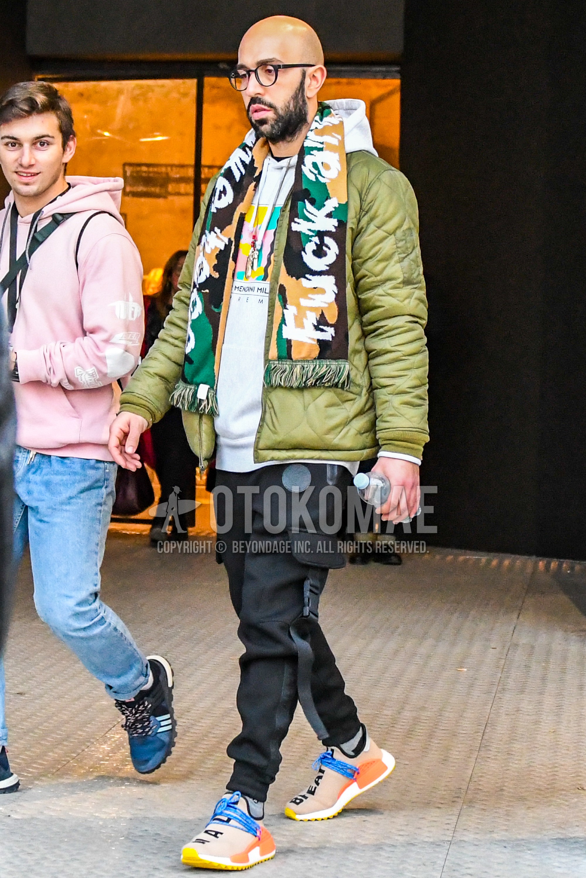 Men's winter outfit with plain glasses, multi-color camouflage scarf, olive green plain quilted jacket, gray plain sweatshirt, black plain cargo pants, black plain sweatpants, black plain jogger pants/ribbed pants, gray plain socks, orange low-cut sneakers.
