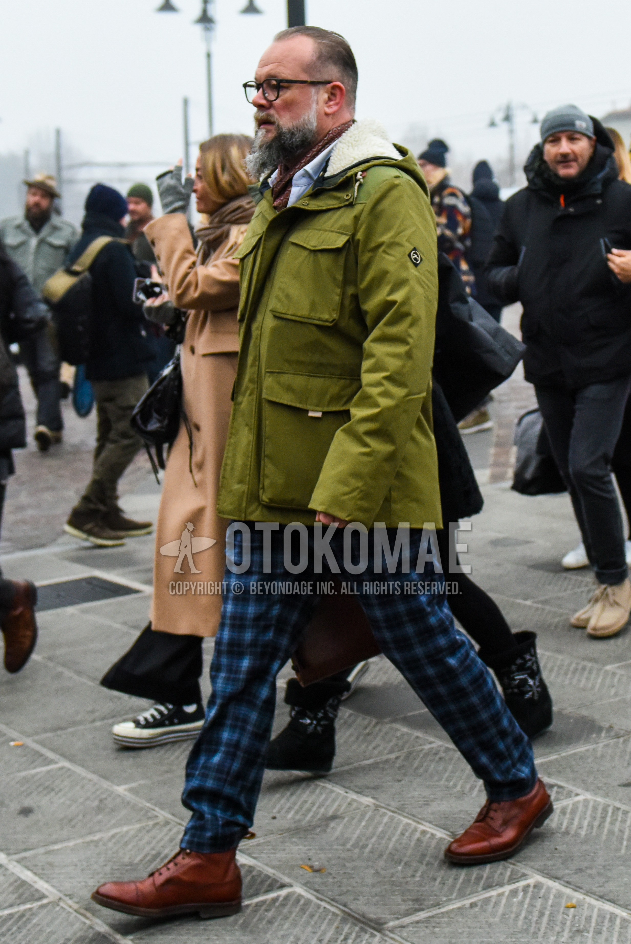 Men's winter outfit with black plain glasses, brown scarf scarf, olive green plain M-65, blue check slacks, brown  boots.