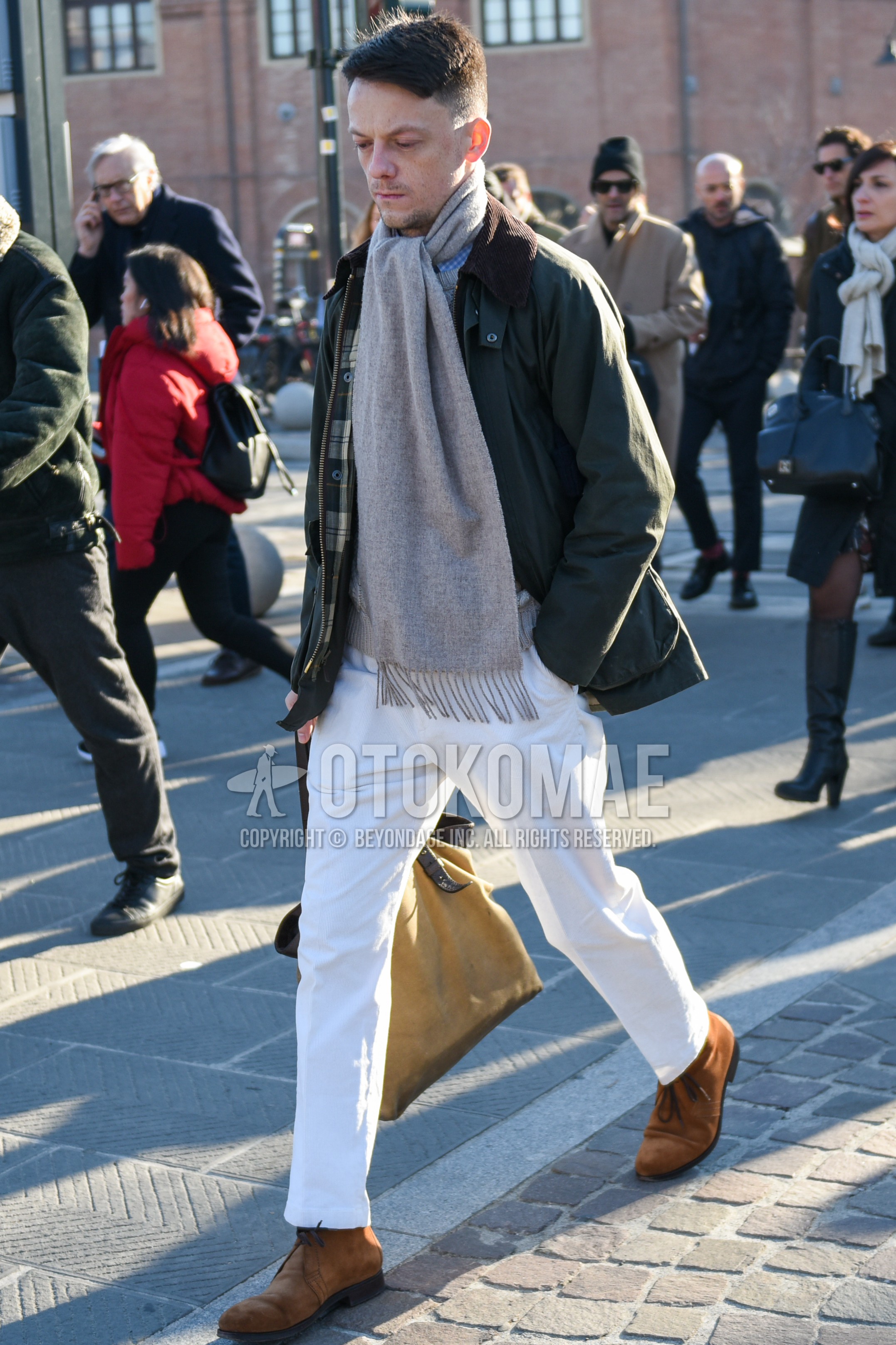 Men's autumn winter outfit with gray plain scarf, olive green plain field jacket/hunting jacket, white plain cotton pants, brown chukka boots.