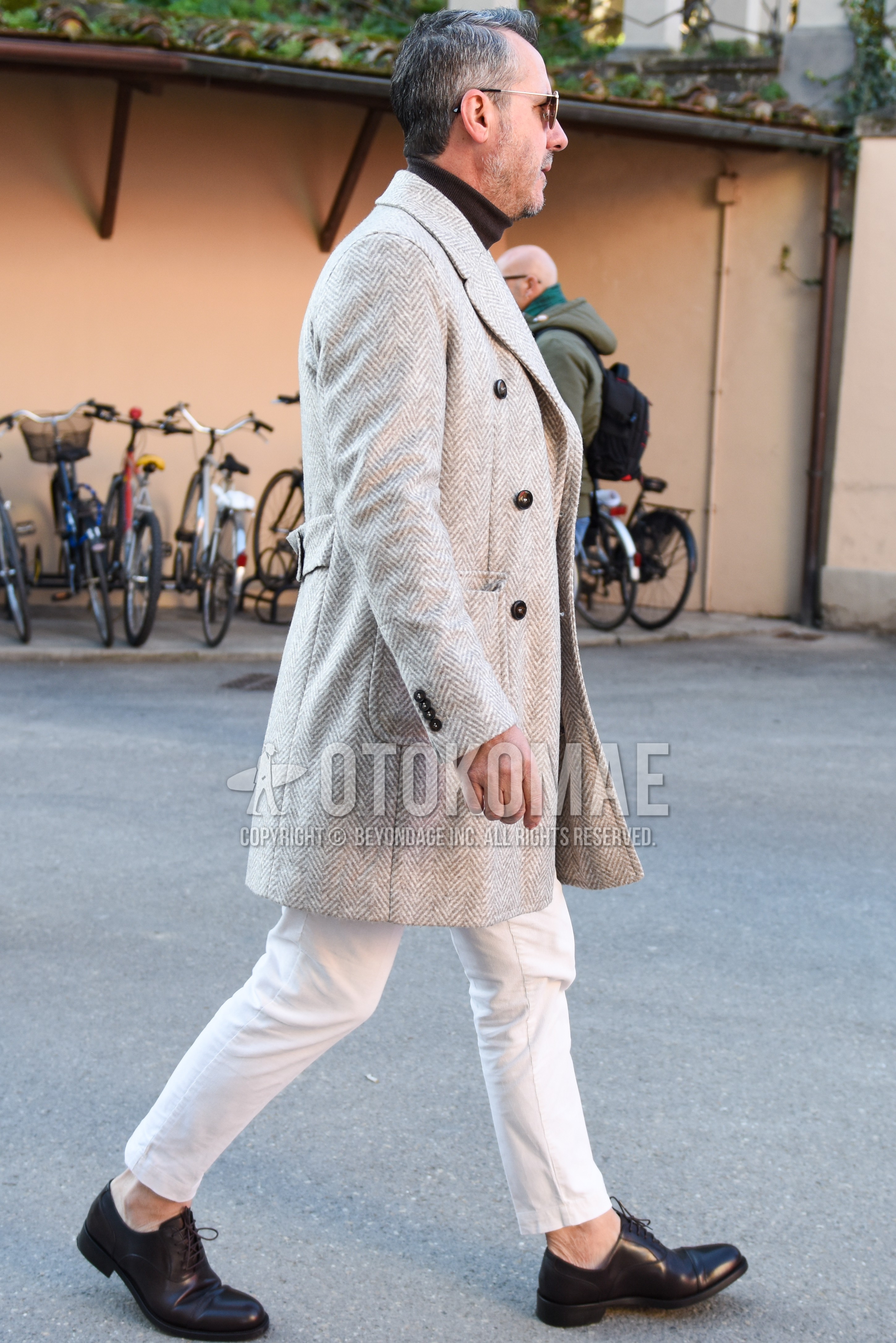 Men's autumn winter outfit with gray herringbone chester coat, black plain turtleneck knit, white plain slacks, white plain ankle pants, black straight-tip shoes leather shoes.