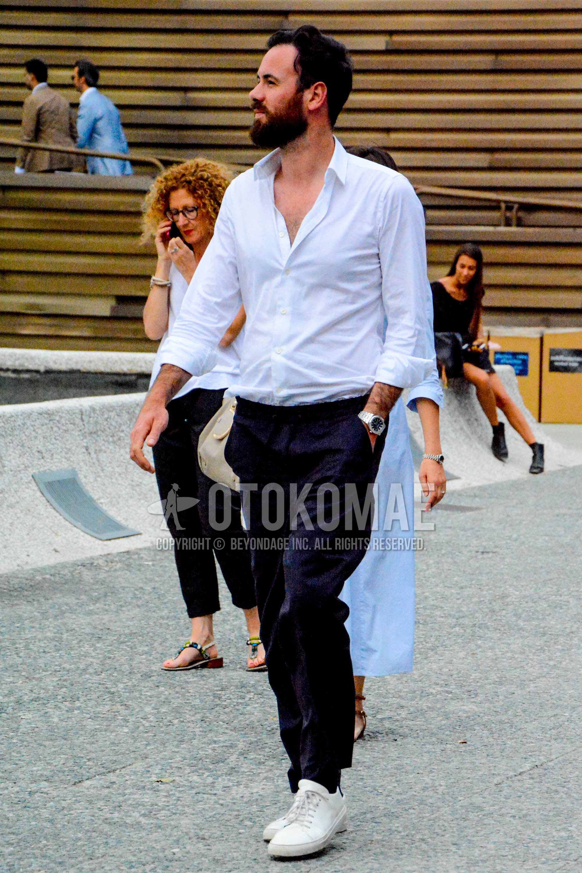 Men's spring summer autumn outfit with white plain shirt, navy plain easy pants, white low-cut sneakers.