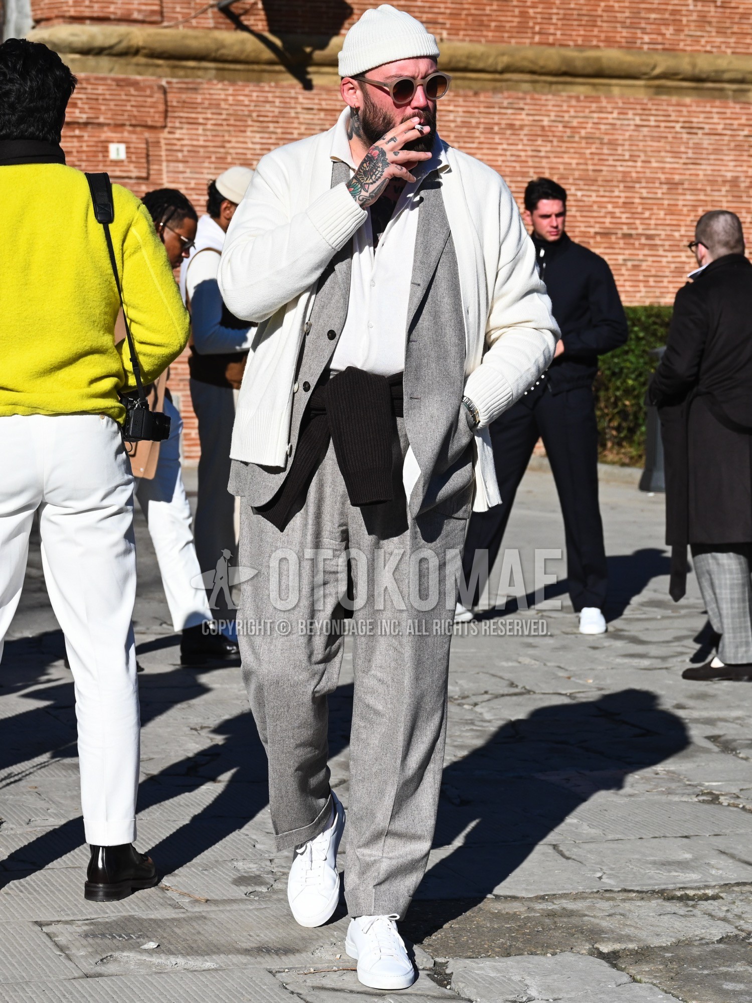 Men's autumn winter outfit with white plain knit cap, beige plain sunglasses, white plain cardigan, black plain t-shirt, white plain shirt, white low-cut sneakers, gray plain suit.