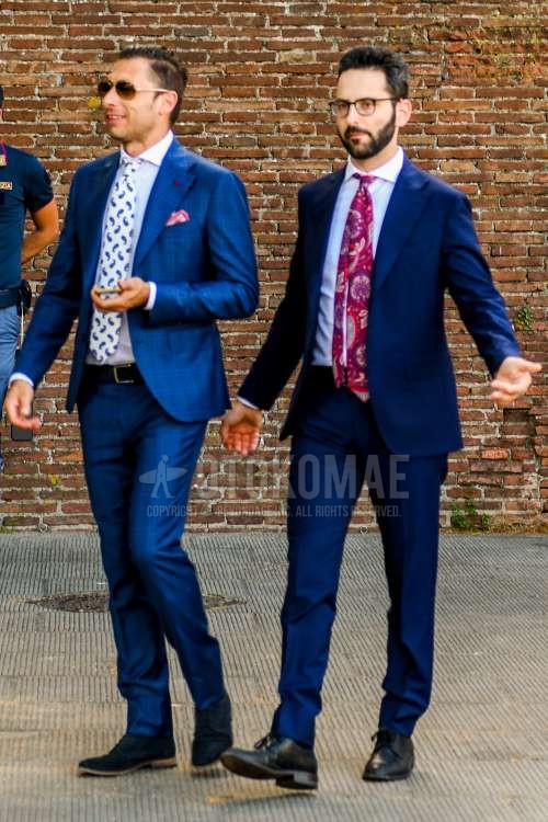 無地のサングラス、無地のメガネ、白無地のシャツ、白無地のシャツ、スエードのネイビープレーントゥの革靴、黒ストレートチップの革靴、ブルーチェックのスーツ、ブルー無地のスーツ、白ネクタイのネクタイ、レッドネクタイのネクタイを合わせた春夏秋のメンズコーデ・着こなし。