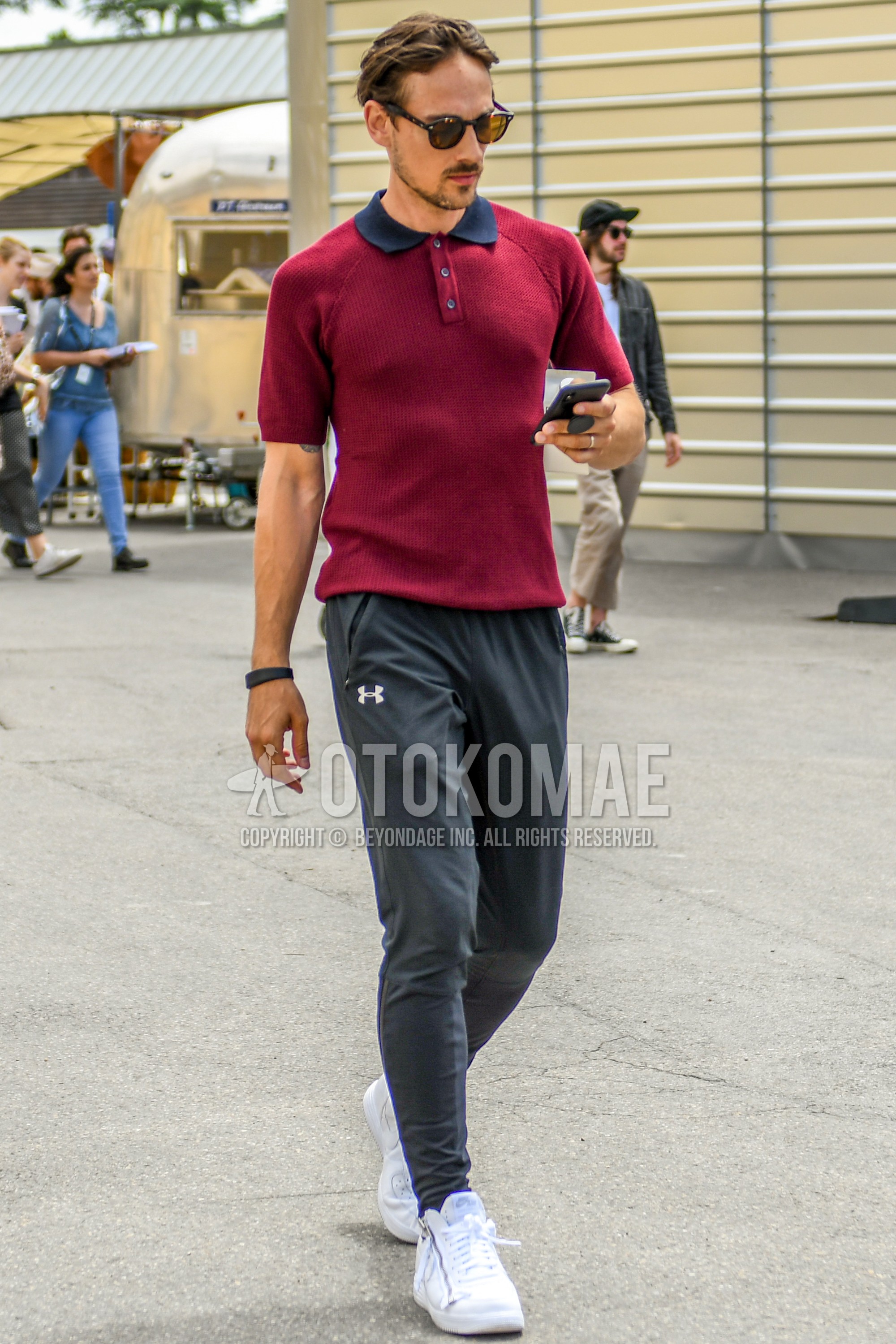 Men's spring summer outfit with brown tortoiseshell sunglasses, red plain polo shirt, gray plain sweatpants, white high-cut sneakers.