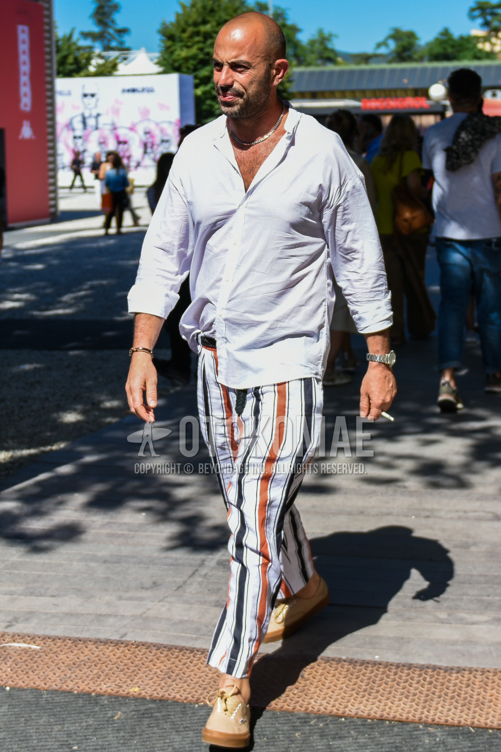 Men's spring summer outfit with white plain shirt, black plain braided belt, plain leather belt, white black beige stripes cotton pants, beige low-cut sneakers.
