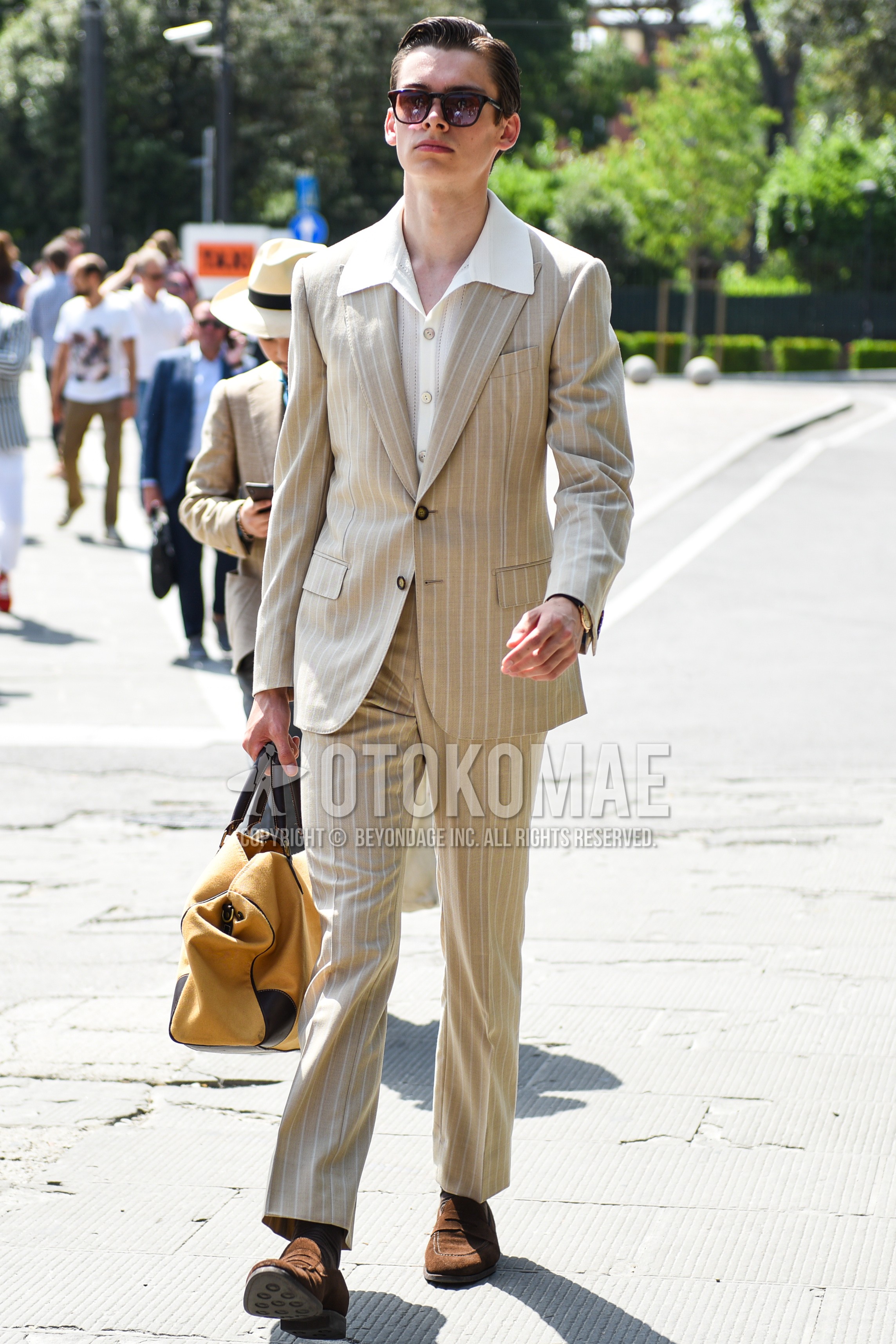 Men's spring summer autumn outfit with black plain sunglasses, white plain shirt, gray plain socks, yellow plain boston bag, beige stripes suit.