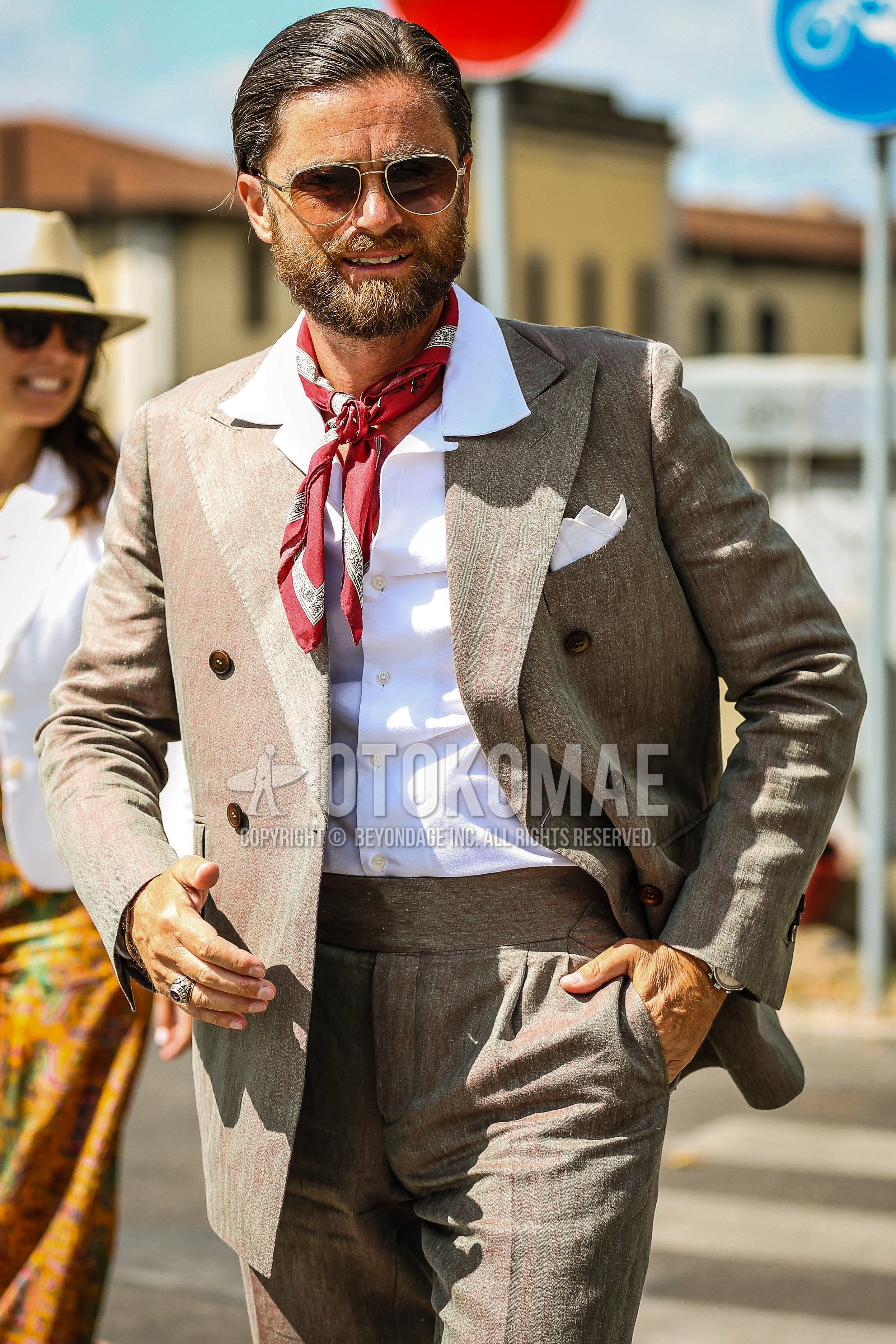Men's spring summer outfit with silver plain sunglasses, red scarf bandana/neckerchief, white plain shirt, beige suit suit.