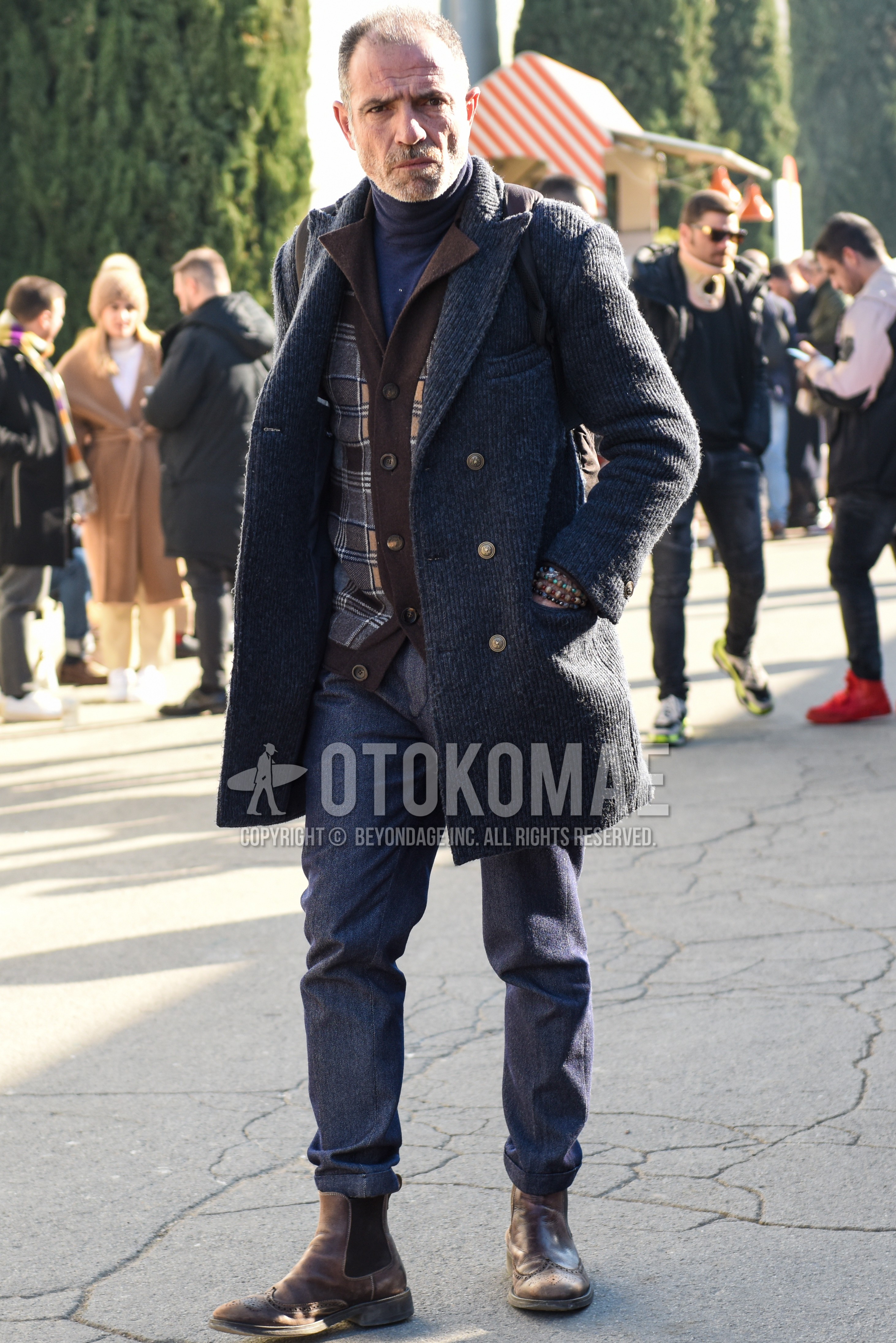 Men's autumn winter outfit with gray plain chester coat, gray brown check cardigan, gray plain turtleneck knit, gray plain slacks, brown side-gore boots.